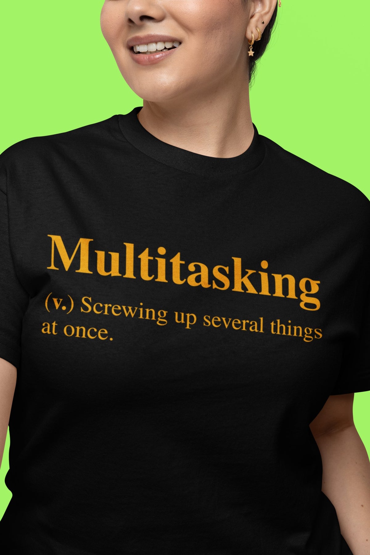Multitasking definition tee in black, woman on a bright green backdrop, funny office gift