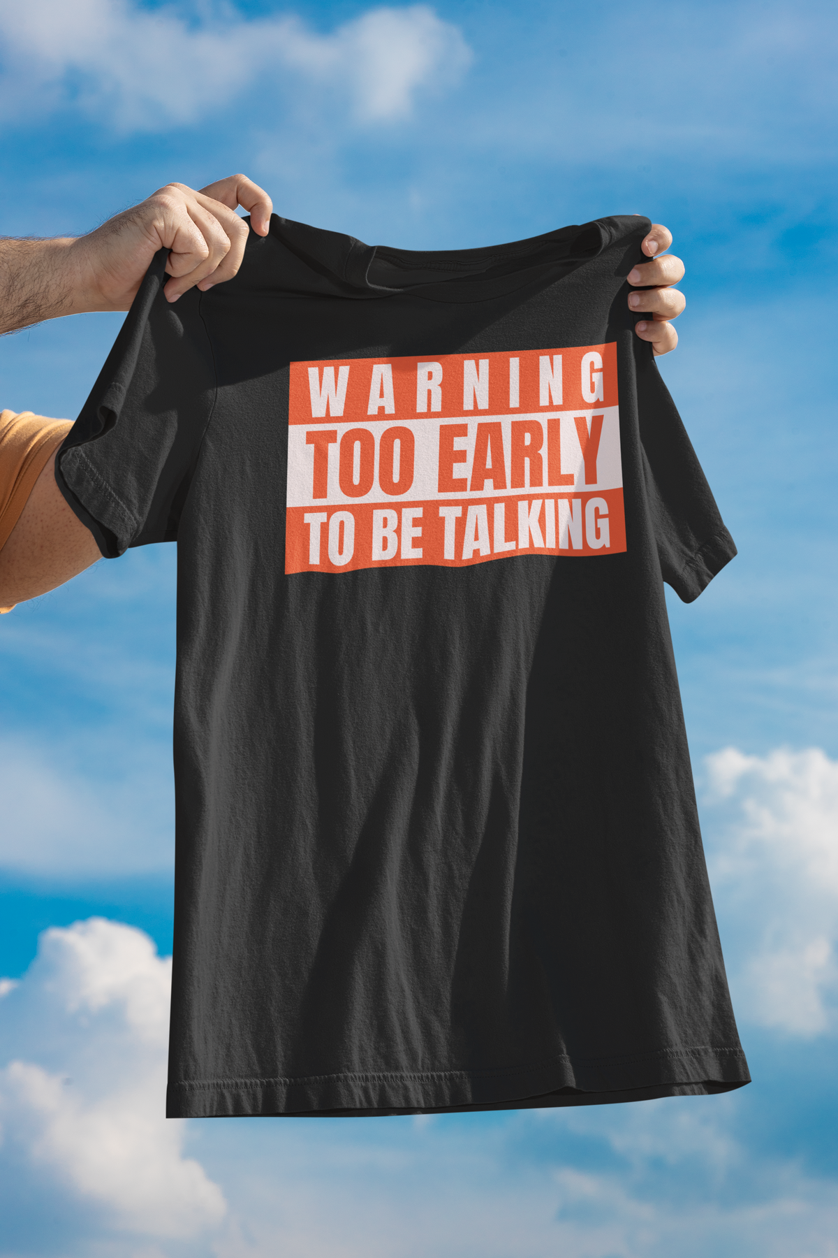 'Warning Too Early To Be Talking' t-shirt in black, man holding it up outdoors, funny sarcastic gift