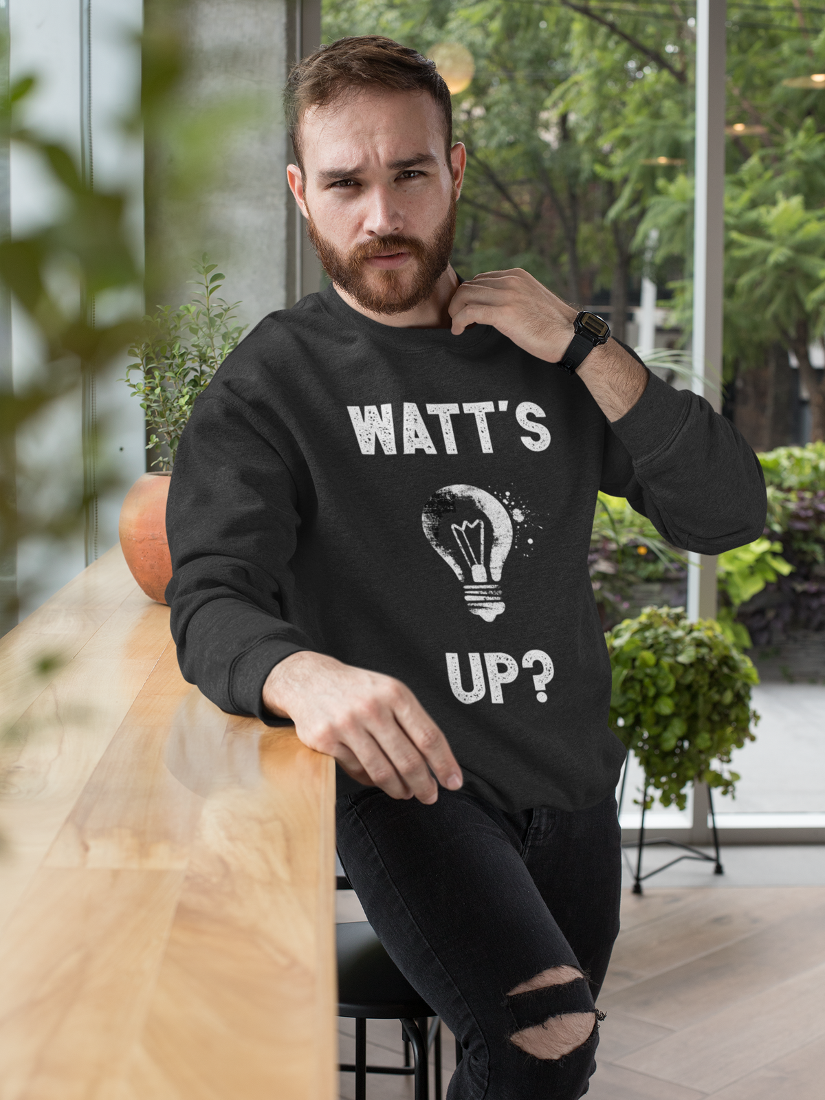'Watt's Up?' sweatshirt in black, bearded man wearing it, funny lightbulb pun sweatshirt gift