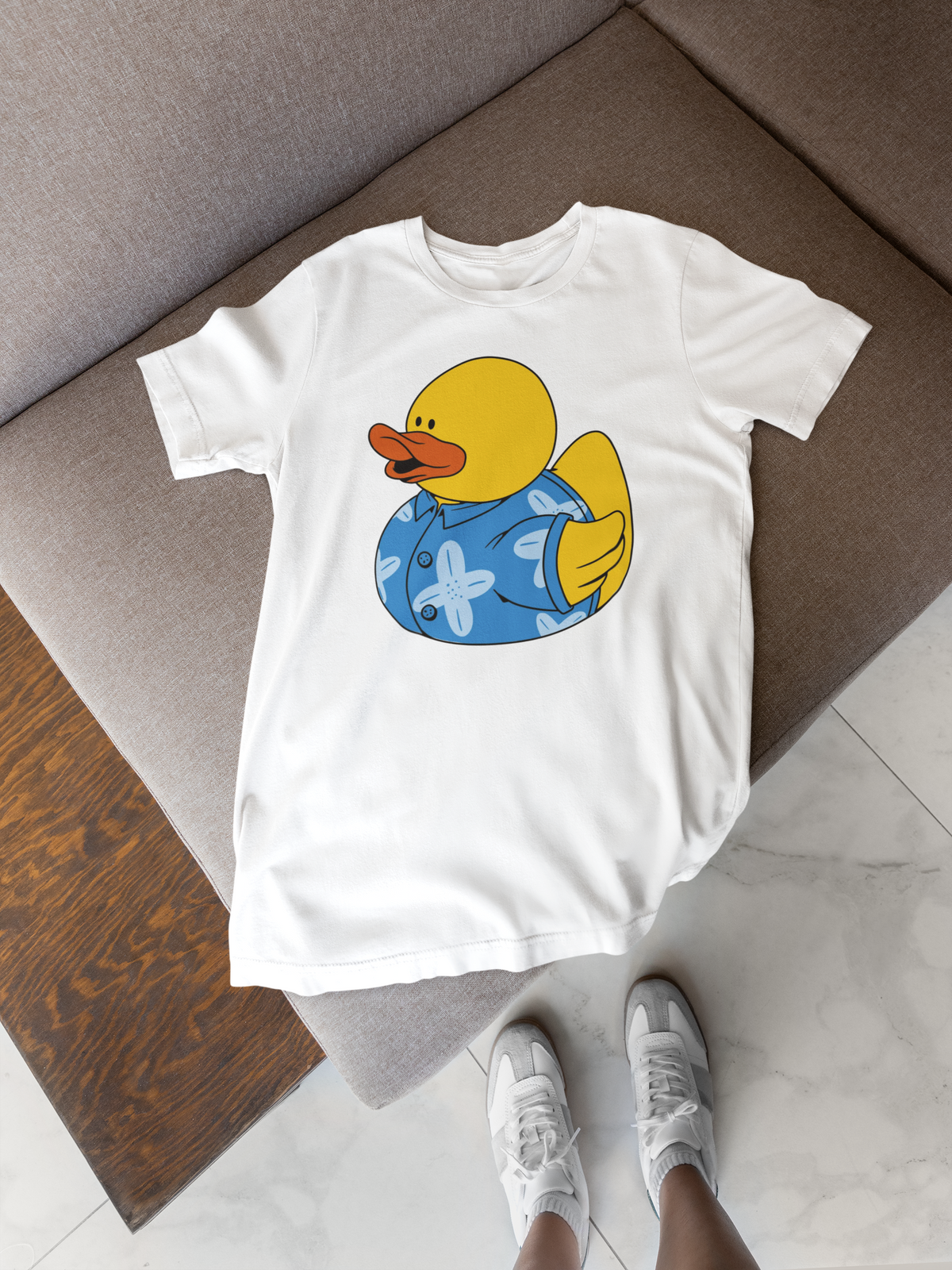 Hawaii duck t-shirt in white, flat lay on a wooden floor with sneakers, funny tropical duck gift
