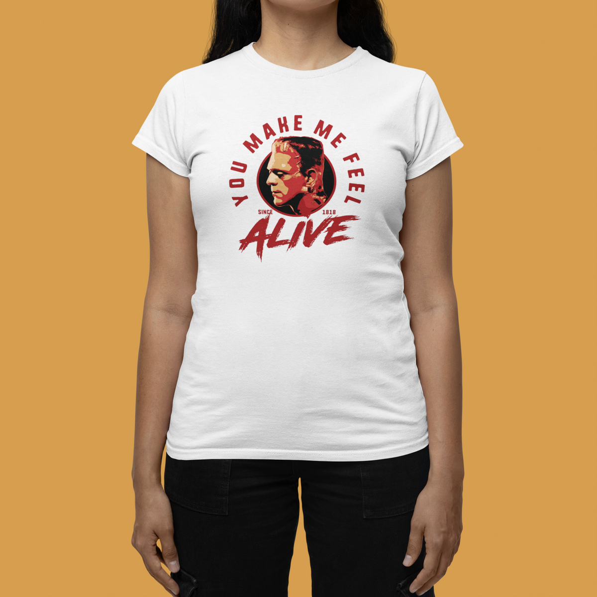 "You Make Me Feel Alive" portrait tee in white, woman wearing it on tan backdrop, funny fan gift for her