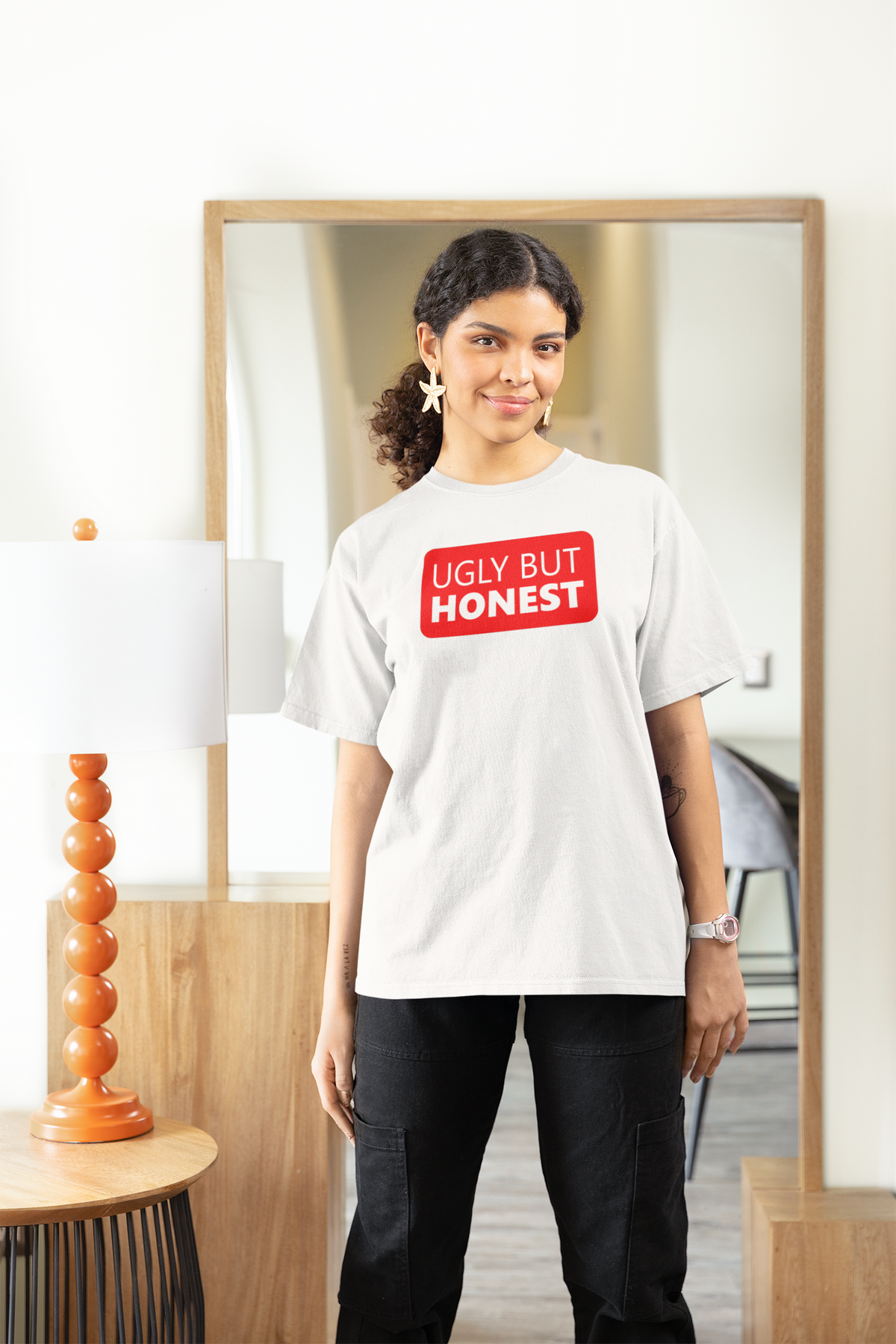 'Ugly But Honest' women's t-shirt in white, woman wearing it at home, funny sarcastic gift