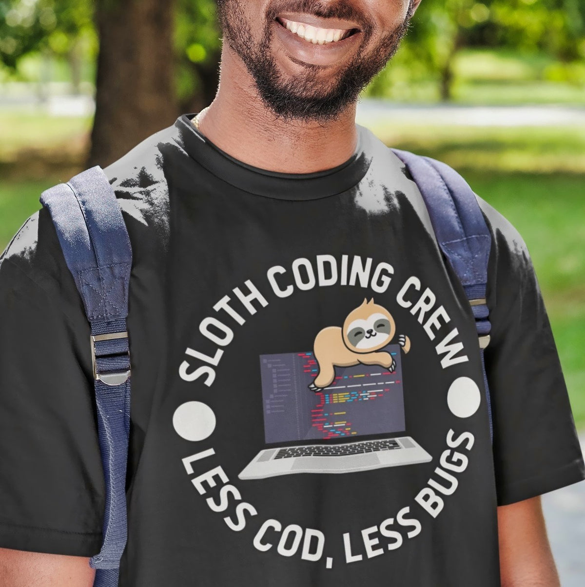Sloth Coding Crew tee in black, close-up on a smiling man with a backpack outdoors, coder gift