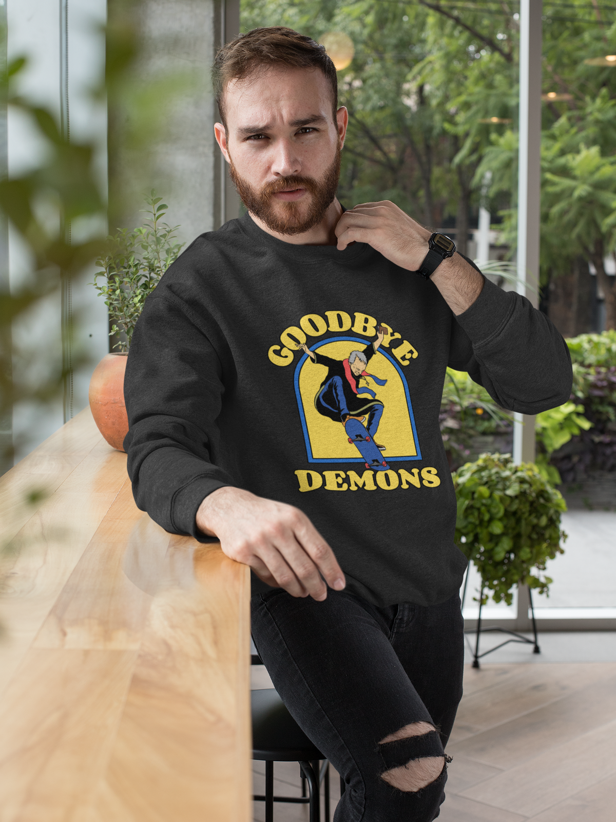 'Goodbye Demons' funny exorcist skater sweatshirt in black, man wearing it outdoors, funny halloween gift