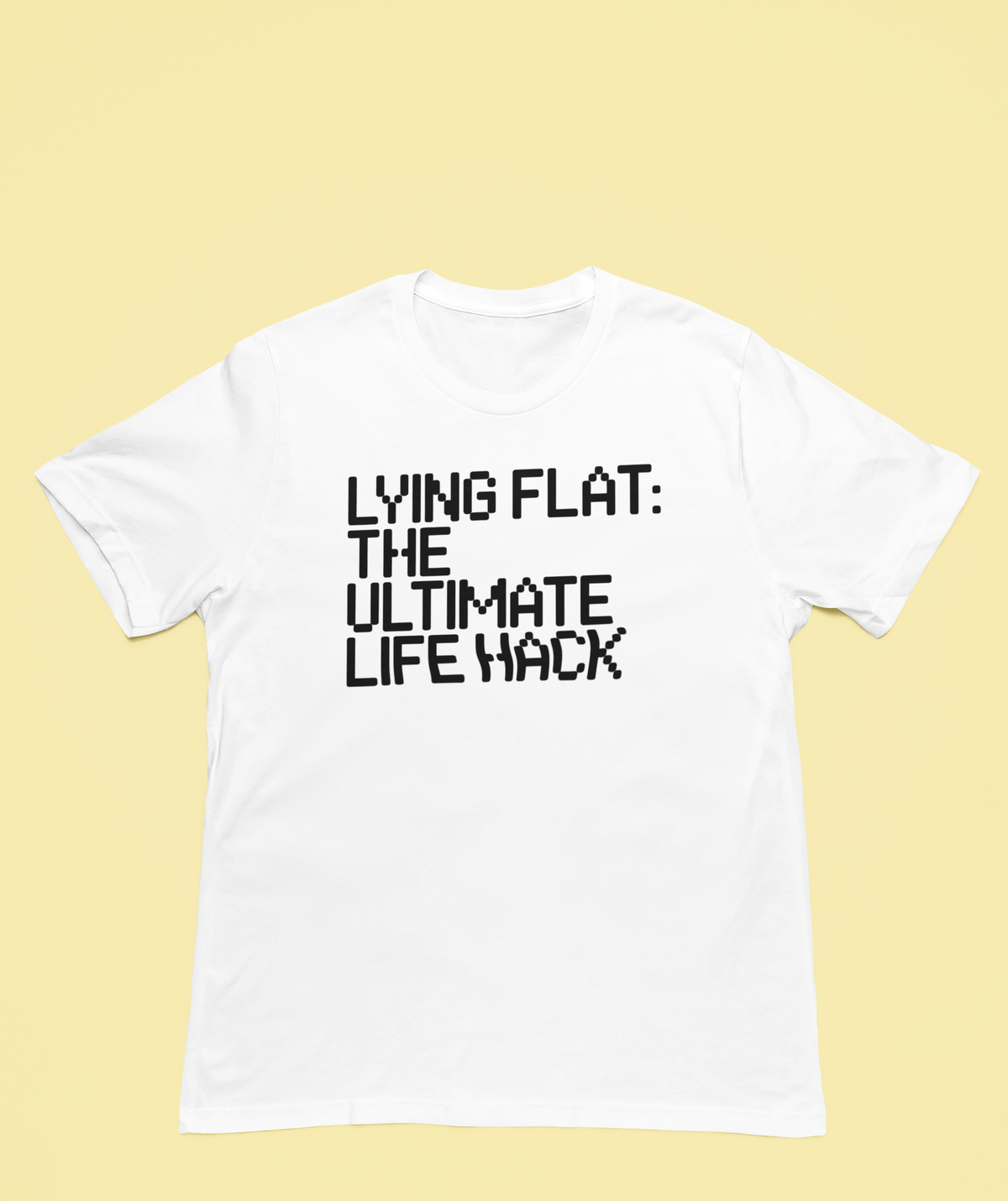 'Lying Flat: The Ultimate Life Hack' t-shirt in white, flat lay on yellow background, funny procrastinator gift