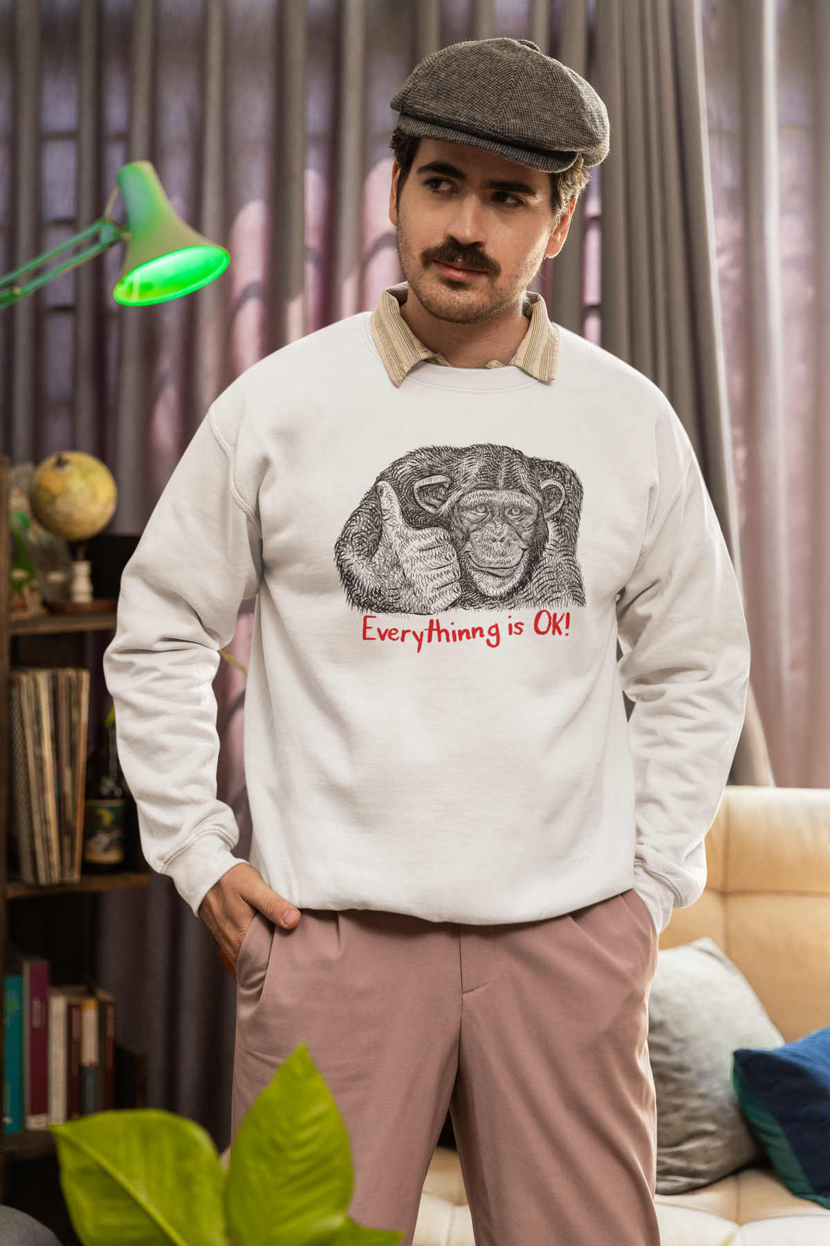 'Everything is OK' monkey sweatshirt in heather beige, man wearing a flat cap indoors, sarcastic gift