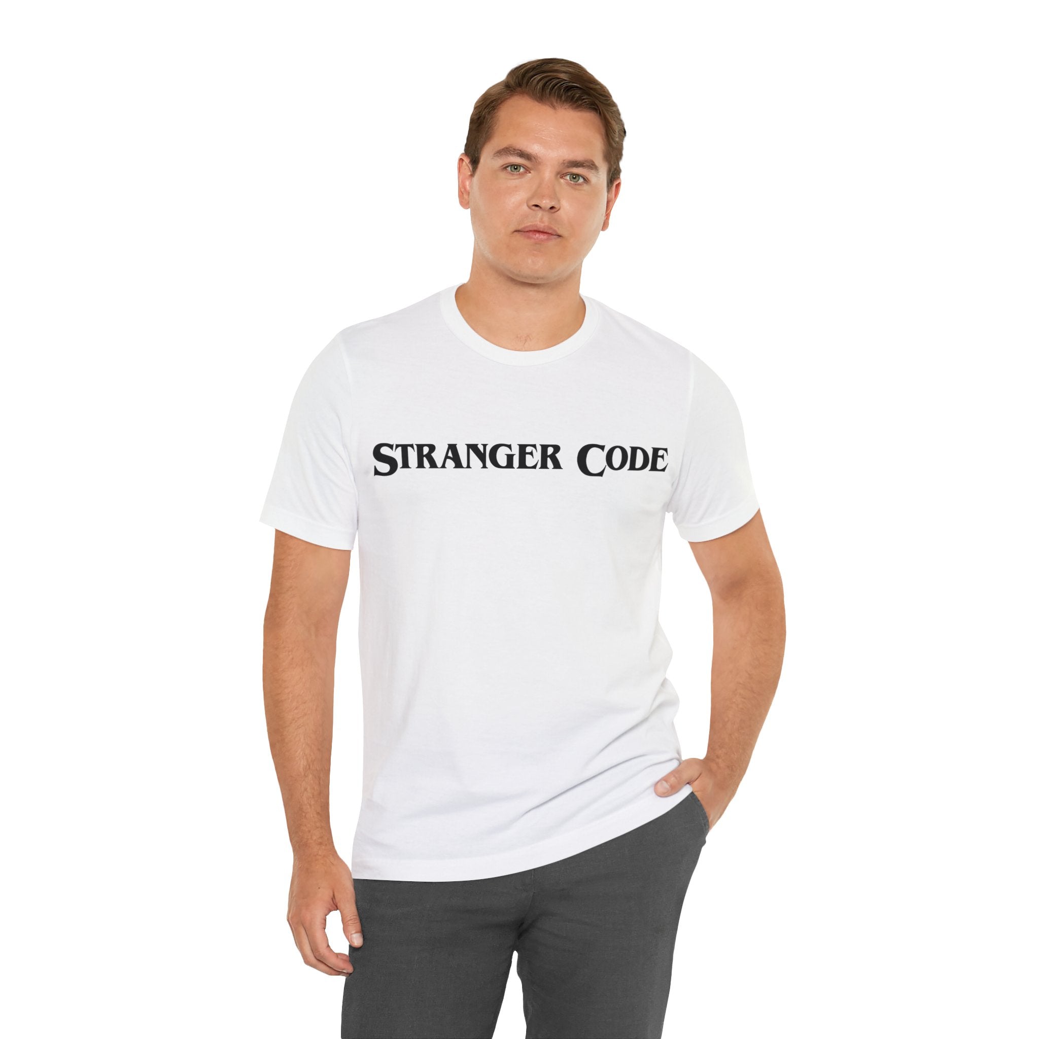 A man wearing the Stranger Code Tee Shirt, a classic unisex jersey made from soft cotton, showcasing the text "STRANGER CODE" on the front.
