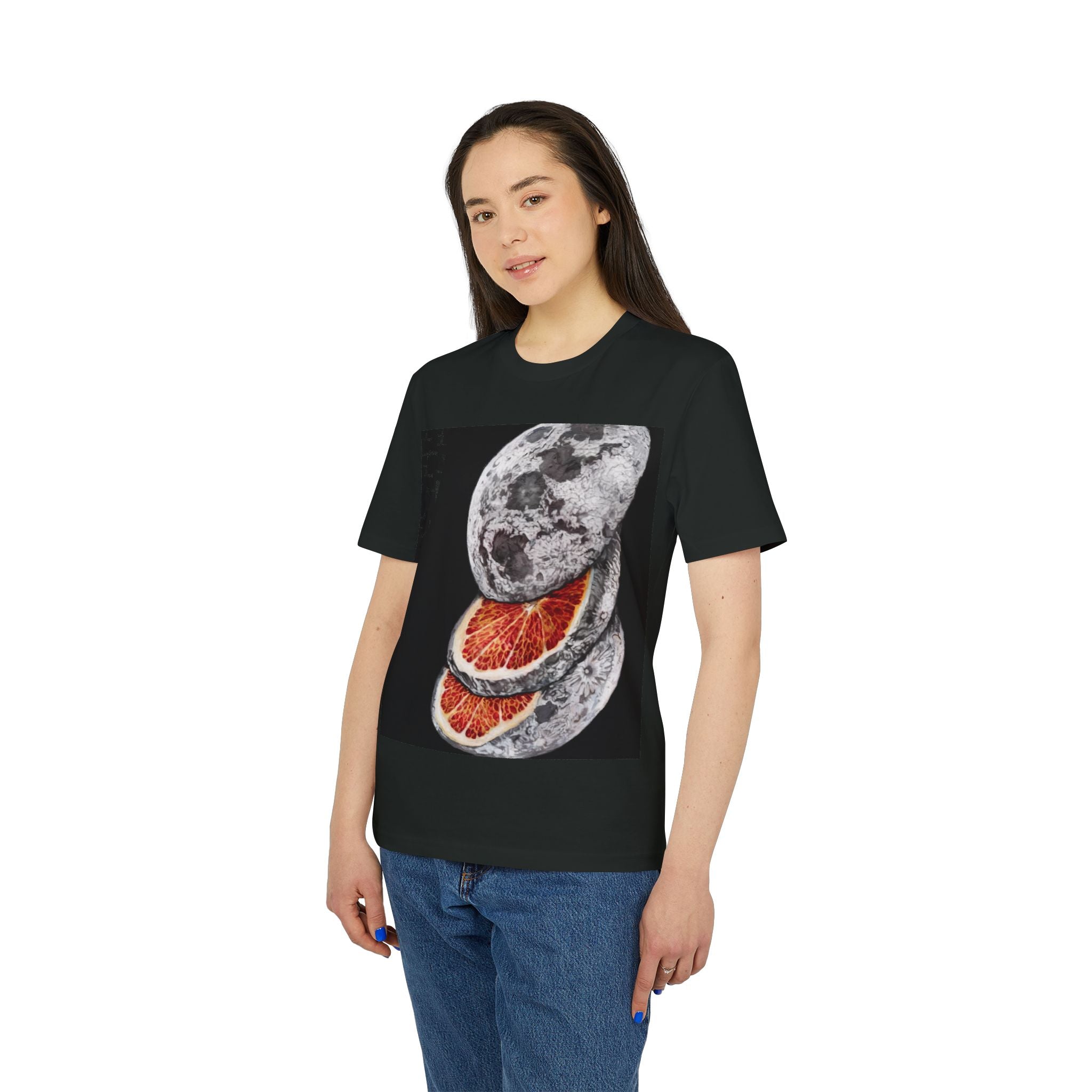 A woman wears the Sliced Moon - Organic T-Shirt, featuring a black sci-fi design with a moon sliced open to reveal a red, citrus-like interior, made from eco-friendly cotton.