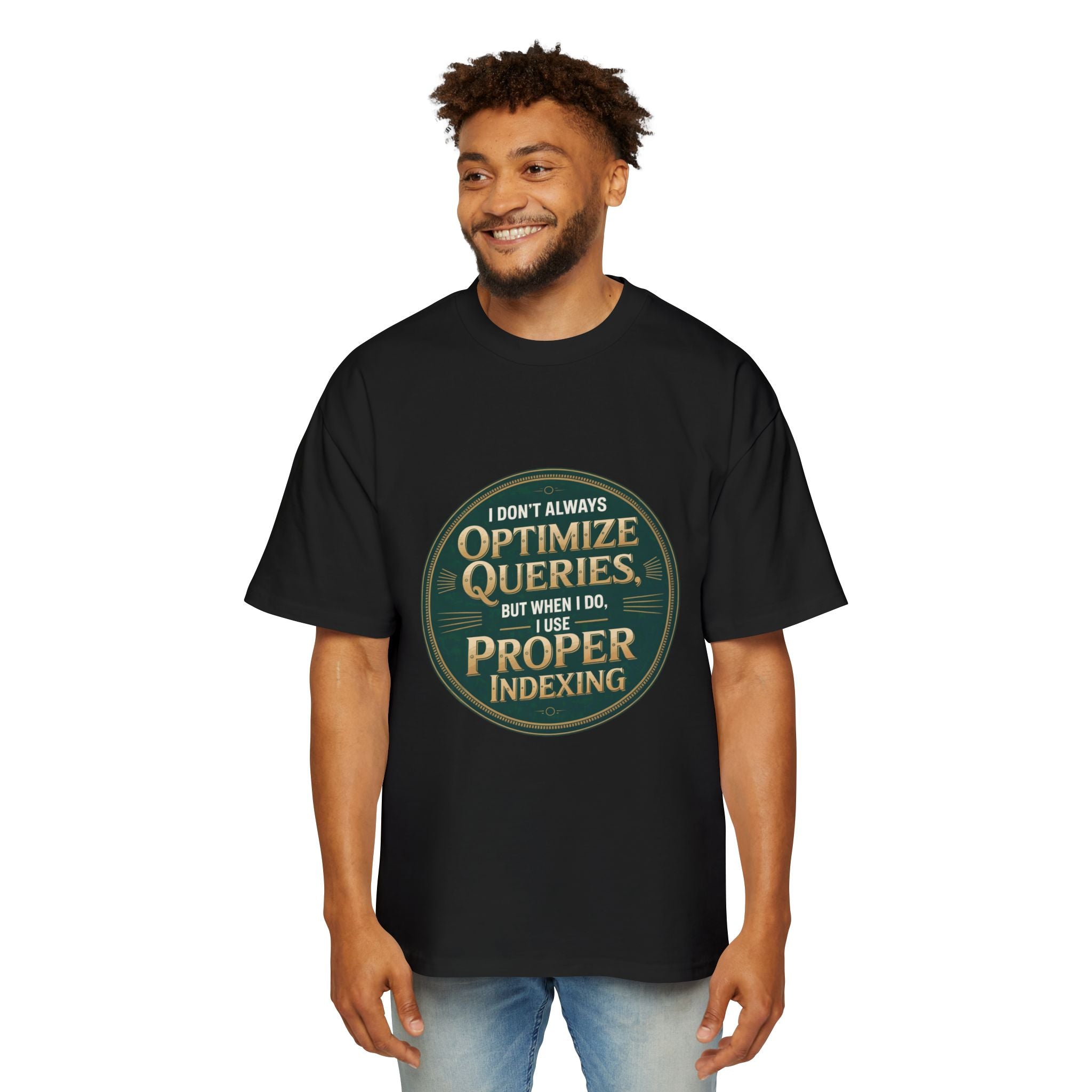 A man smiles against a plain background, wearing the "I Don't Always Optimize Queries - Heavy Oversized Tee," a black, boxy-fit shirt featuring the text: "I don't always optimize queries, but when I do, I use proper indexing.