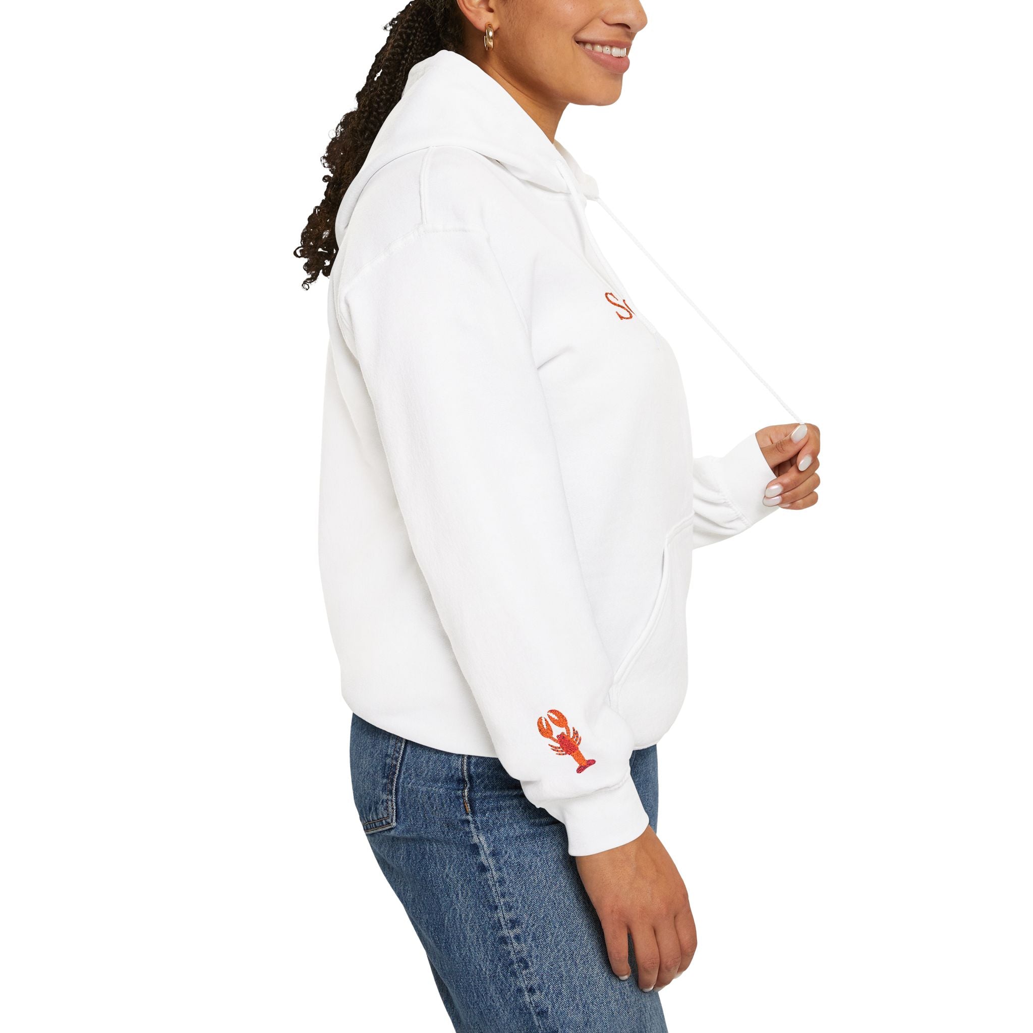 A woman in a Set Them Free Hoodie — Claude / OpenClaw Moltbot AI Graphic Hoodie, featuring a white design with a small red lobster graphic on the sleeve, pairs it with blue jeans and stands in side profile.