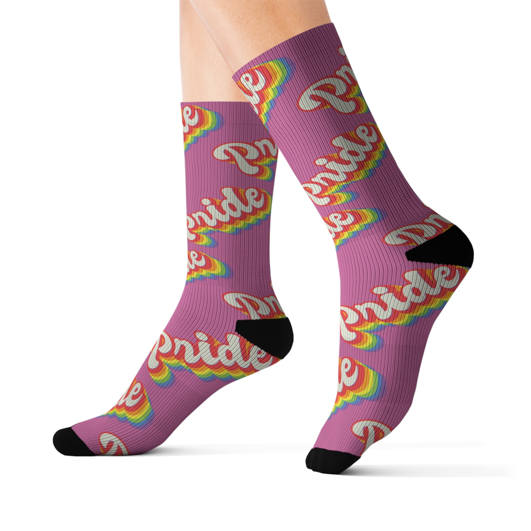 A person is wearing high-quality Pride Socks with a sublimated print and the word "Pride" in rainbow colors, featuring black heels and toes.