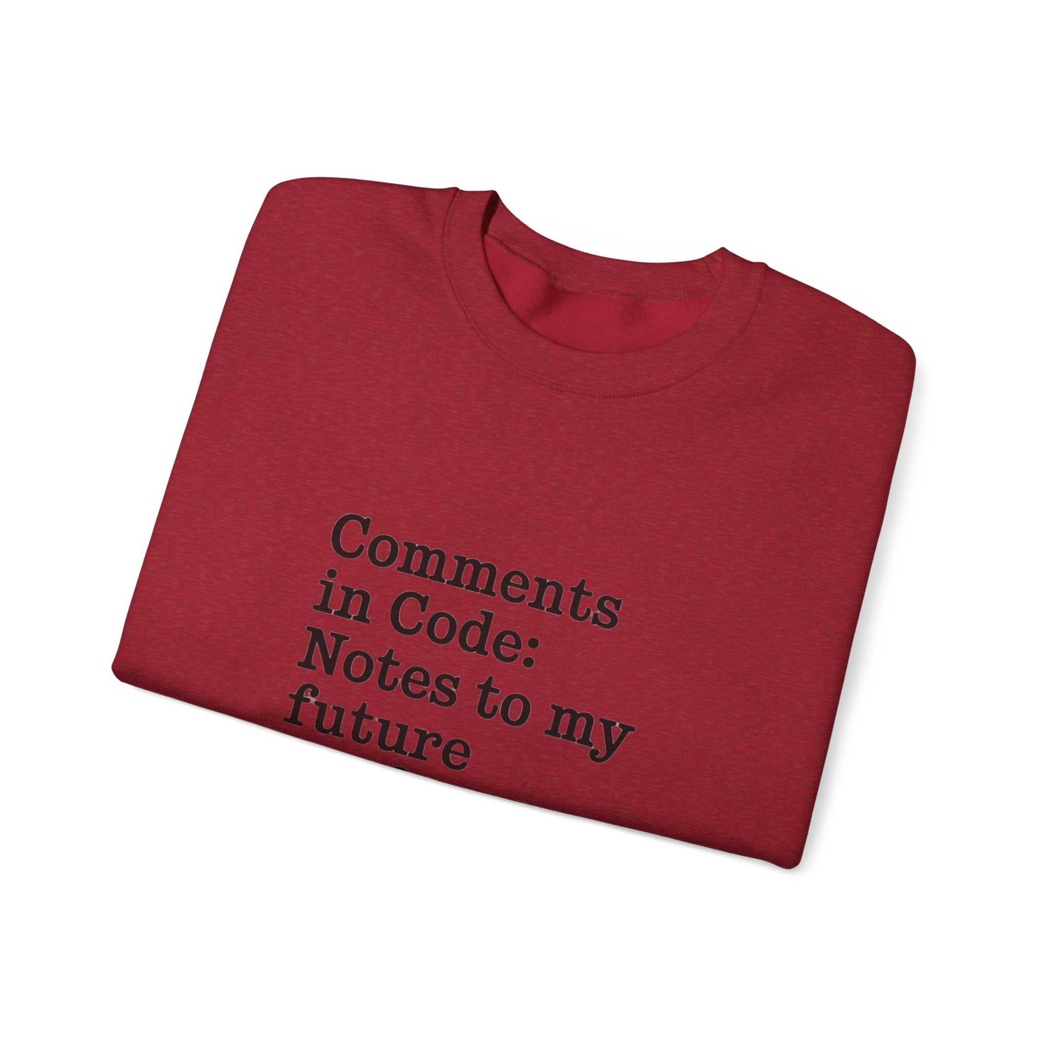 A folded red "Comments in code - Sweatshirt," made from sustainable cotton, features the printed text: "Comments in Code: Notes to my future.