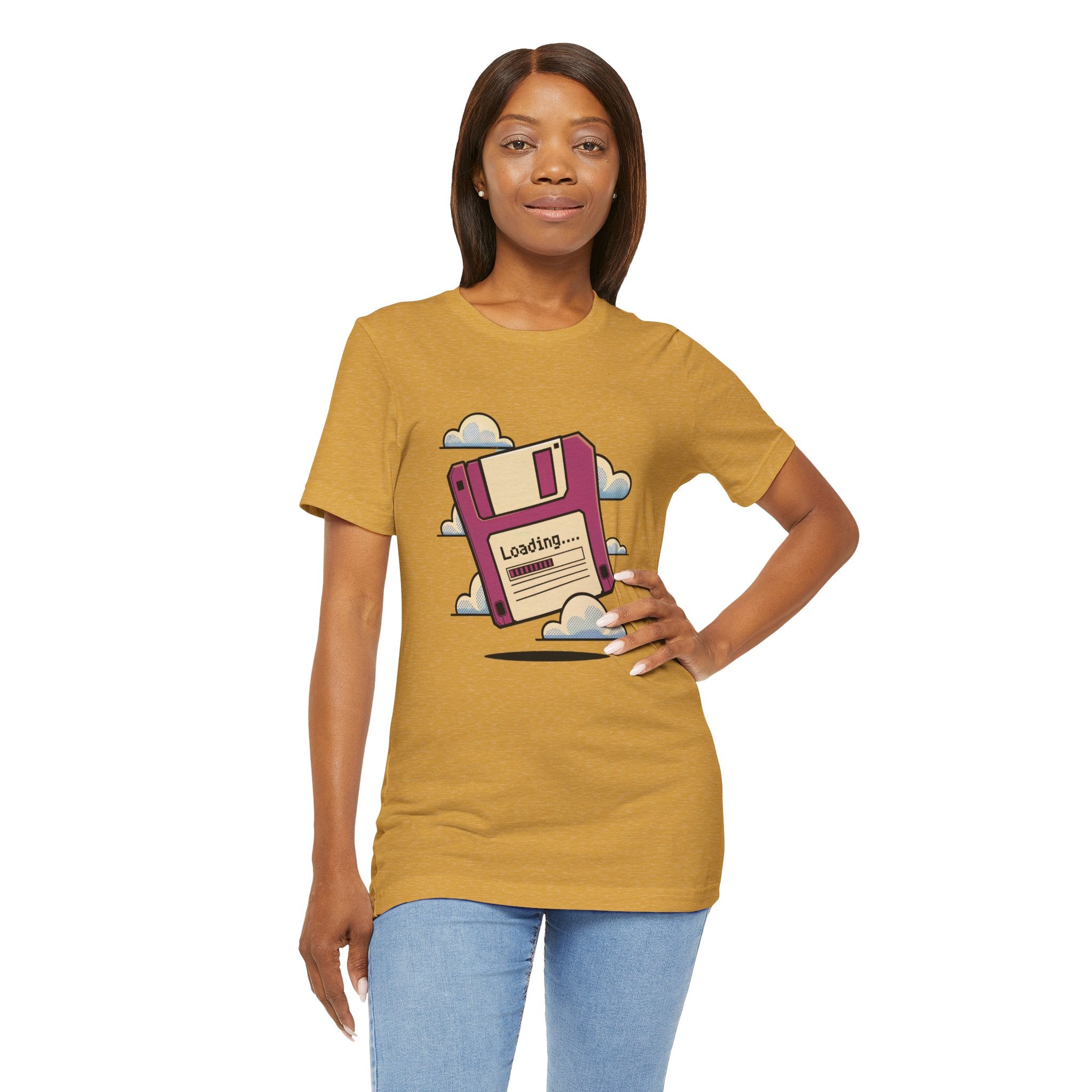 A woman stands facing forward, wearing the Floppy disk -T Shirt, a soft cotton tee with tapered shoulders and a "Loading..." floppy disk illustration surrounded by clouds.