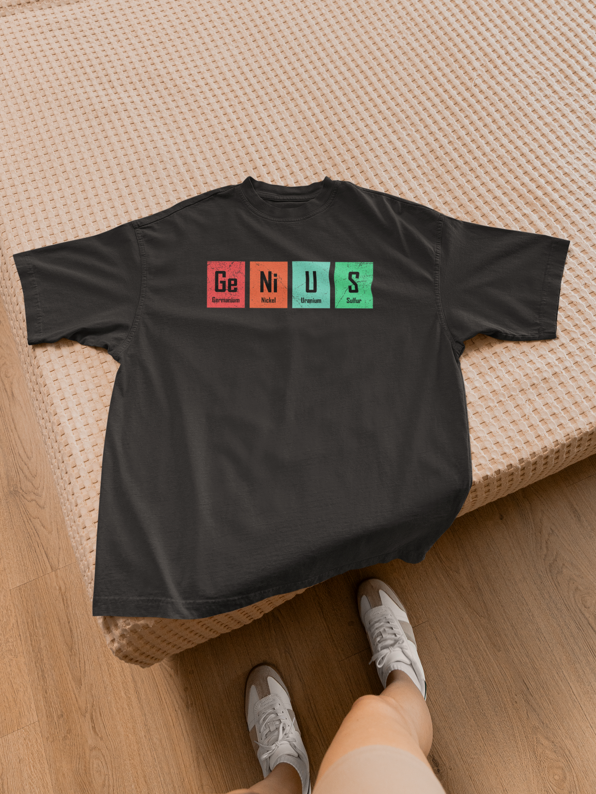 'Genius' periodic table pun women's tee in black, flat lay with sneakers, funny science tee gift