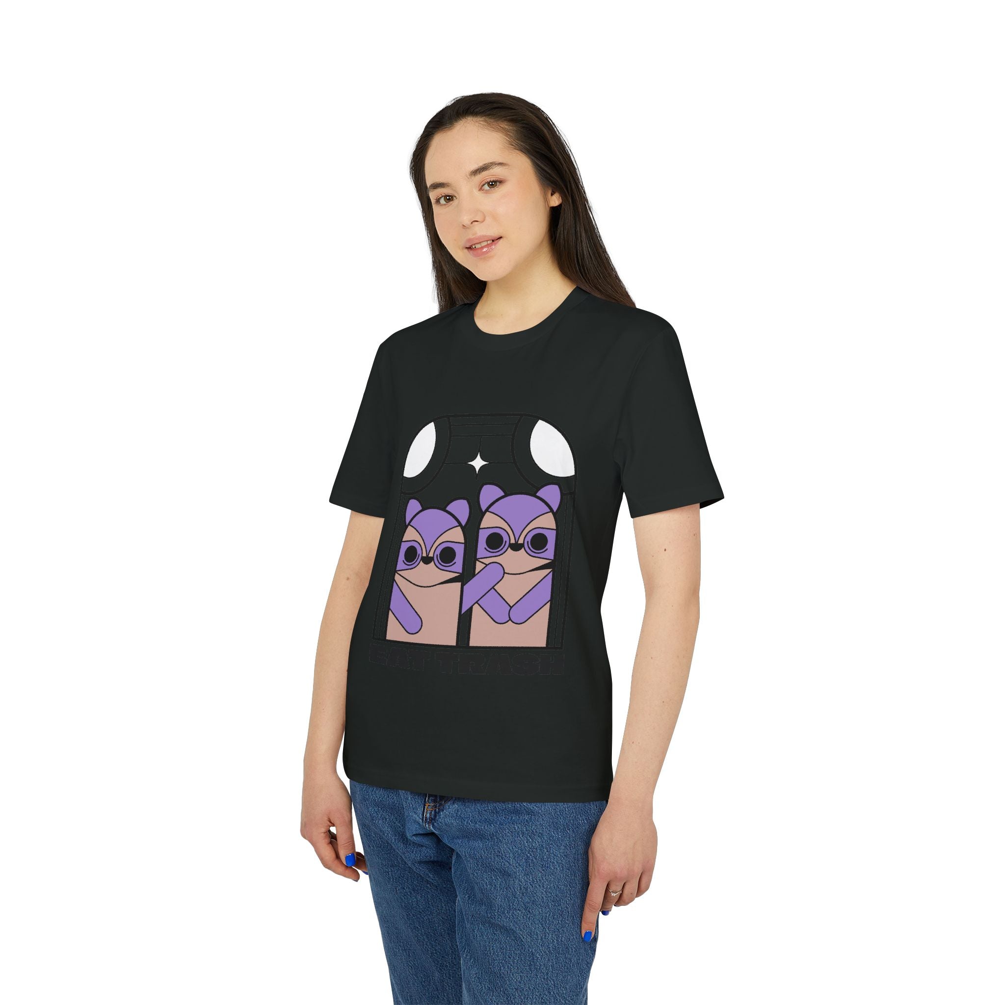 A woman wears the Eat Trush Organic T-Shirt, a black cotton tee with a purple cartoon of two animals in separate windows under a moon and star.