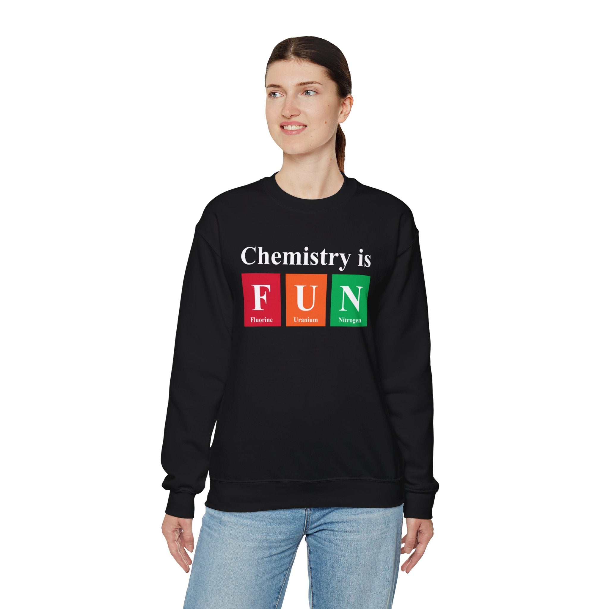 A person proudly wears the "Chemistry is FUN - Sweatshirt" in black, featuring periodic table element symbols to express their love for science.