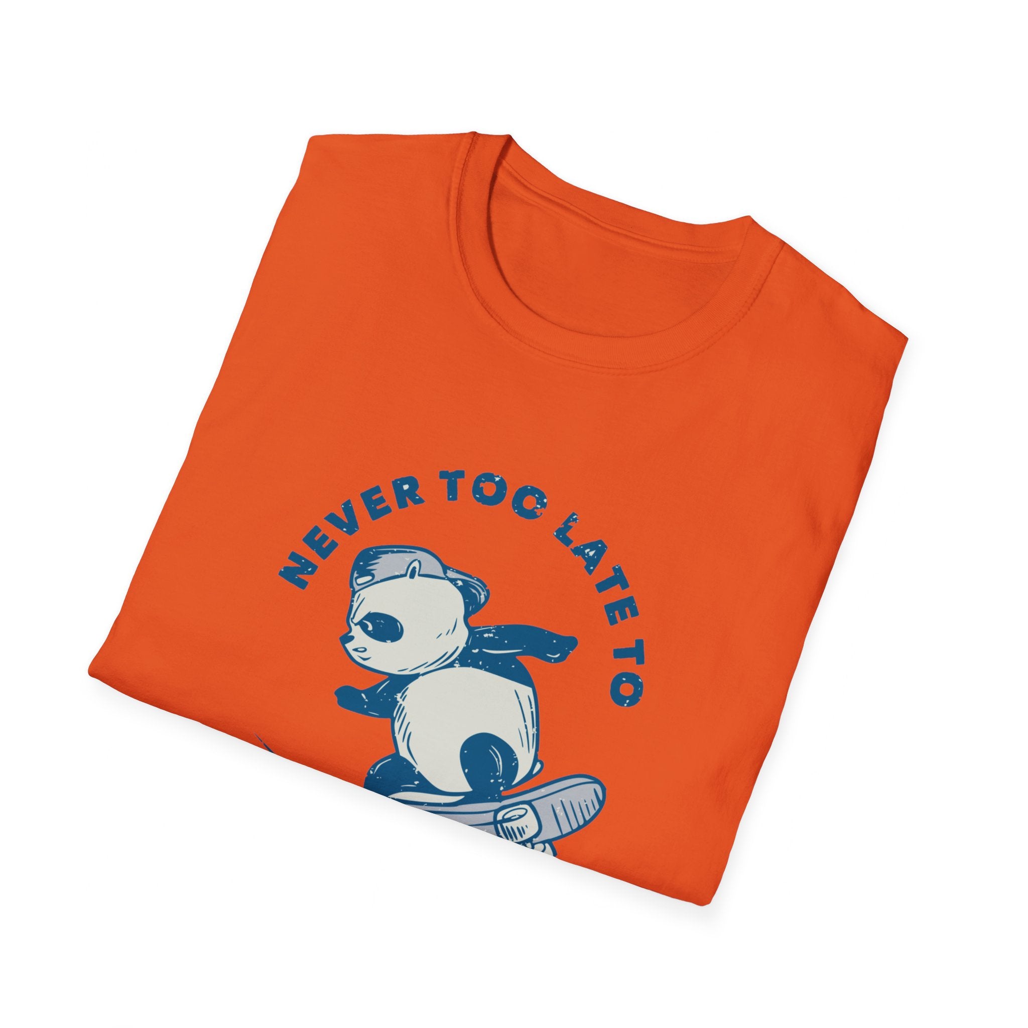 The Never Too Late to Skate T-Shirt is an orange tee showcasing a graphic of a panda in a cape riding a skateboard, with bold text above declaring the timeless passion for skating.
