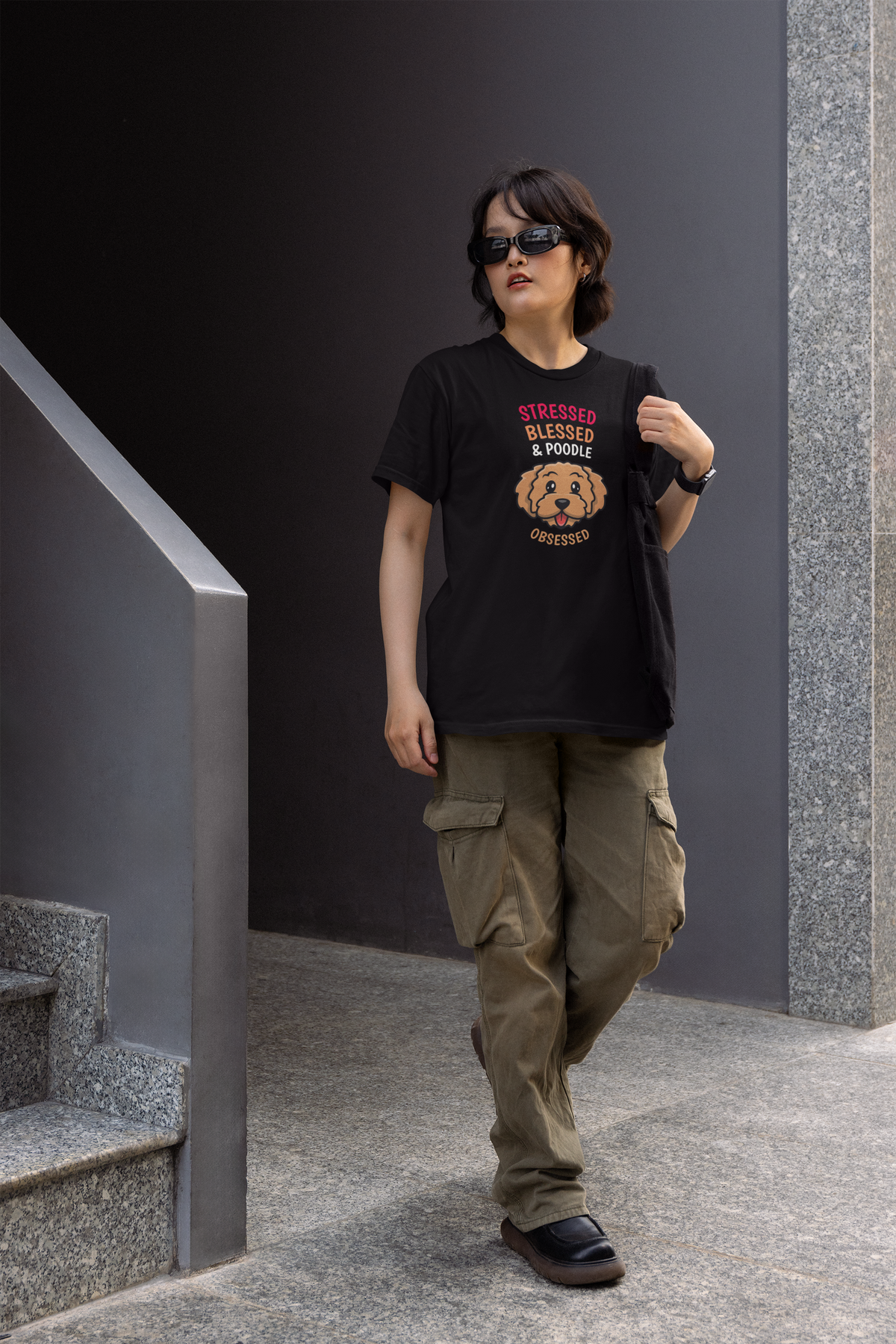 'Stressed Blessed & Poodle Obsessed' women's t-shirt in black, woman walking outdoors, poodle gift