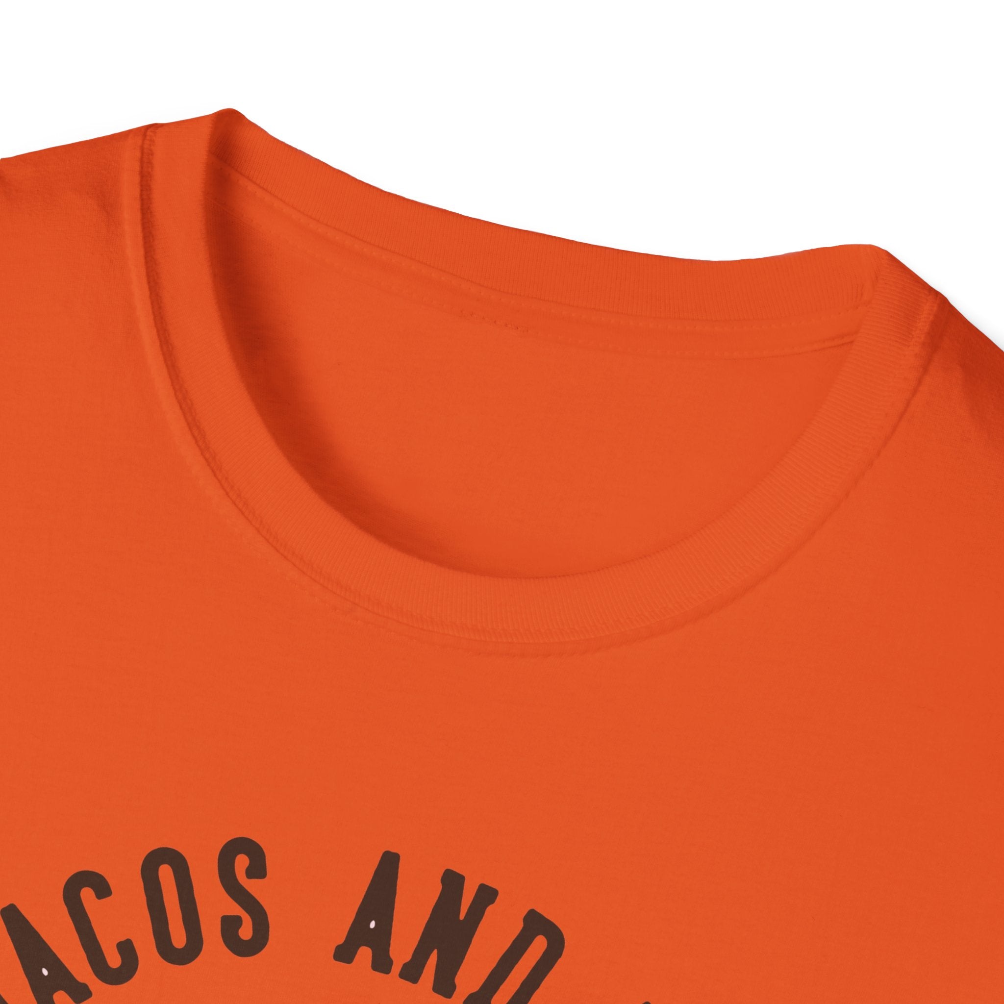 A T-shirt in orange with partially visible black arched text, ideal for taco enthusiasts who adore Taco Tuesdays. Product Name: Feed Me Tacos and Tell Me I'm Pretty.