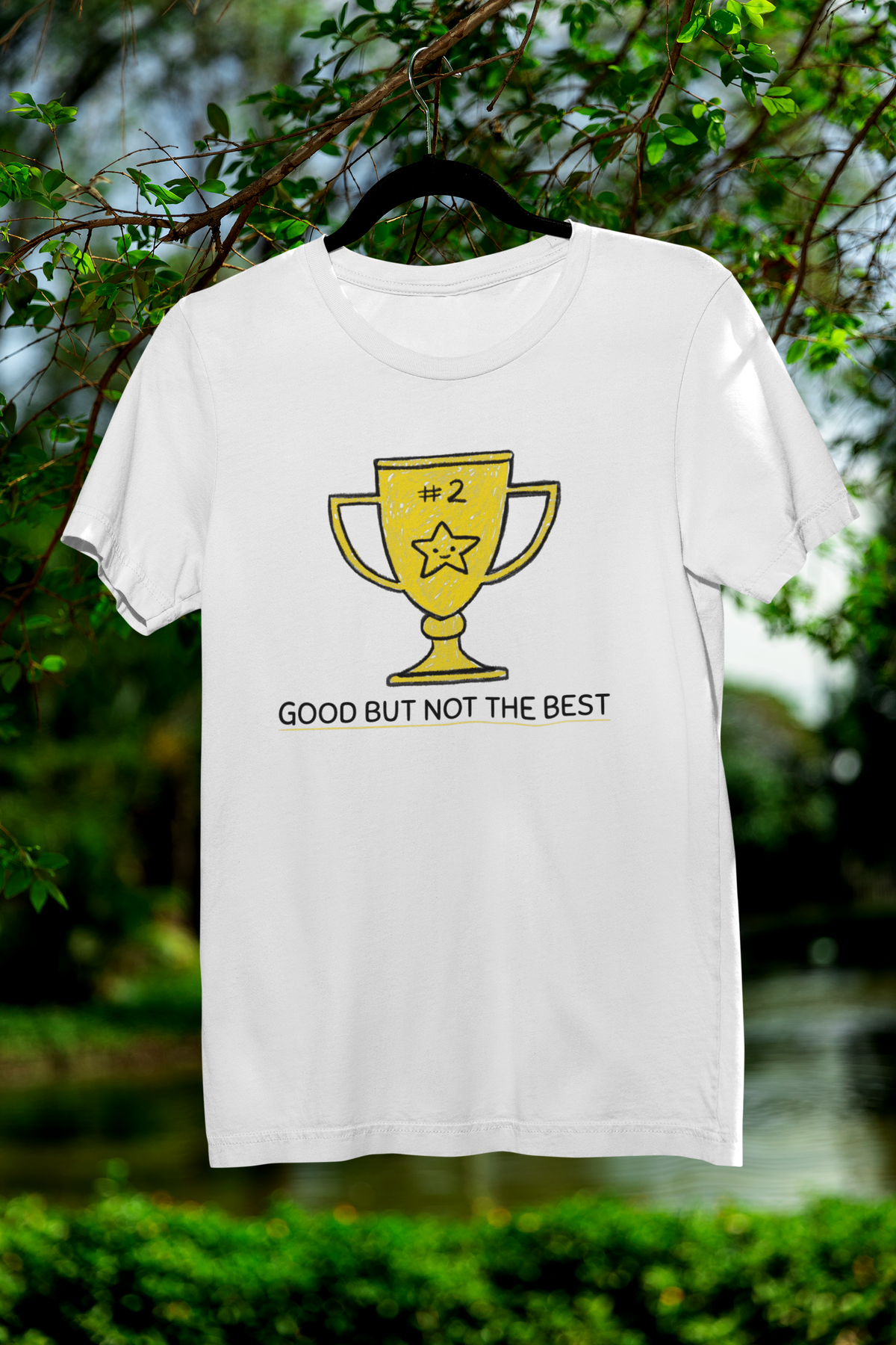 'Good But Not the Best' trophy tee in white, flat lay on hanger outdoors, funny graphic t-shirt gift