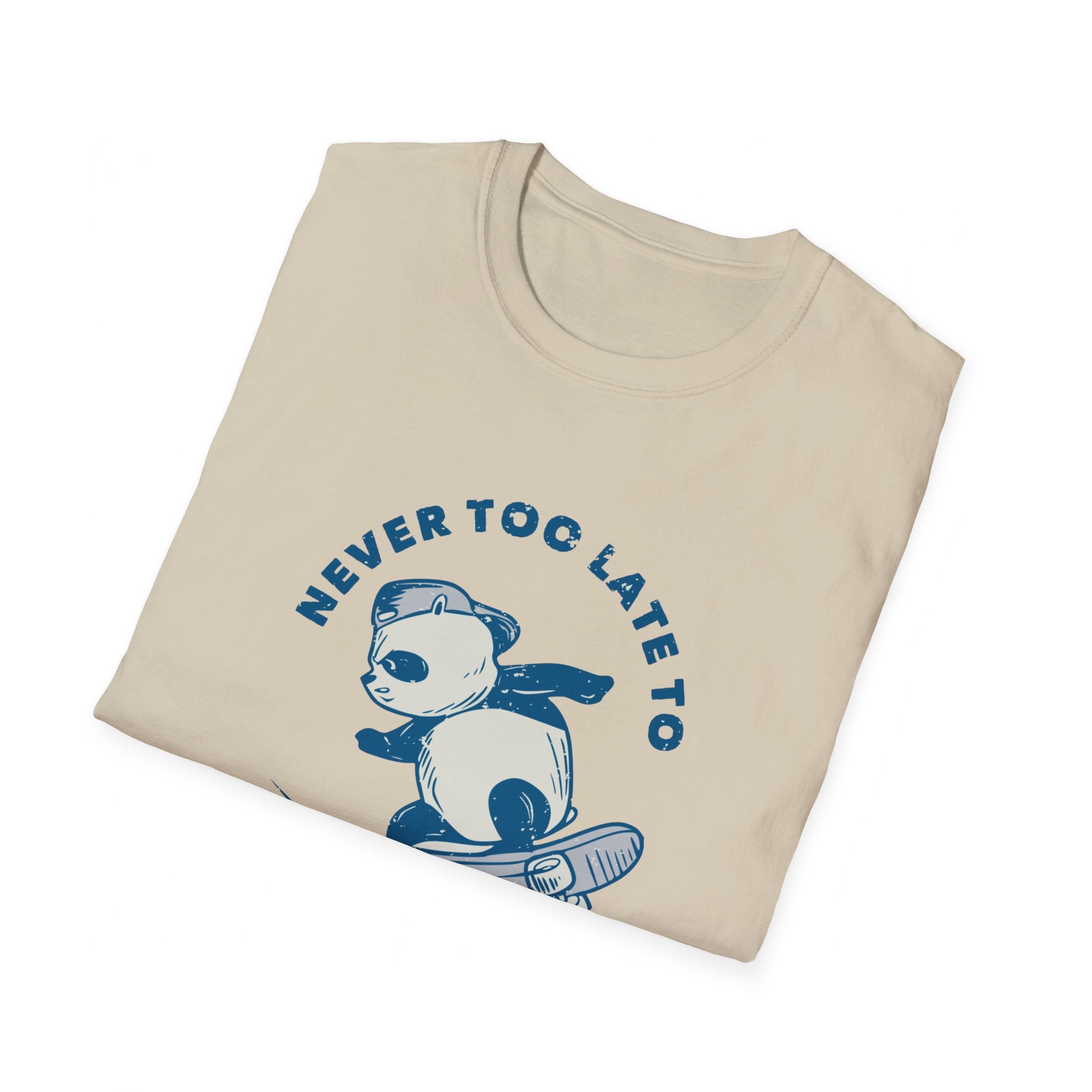 A beige skate tee shirt featuring a panda in a cape riding a skateboard, with the phrase "Never Too Late to Skate" displayed above.