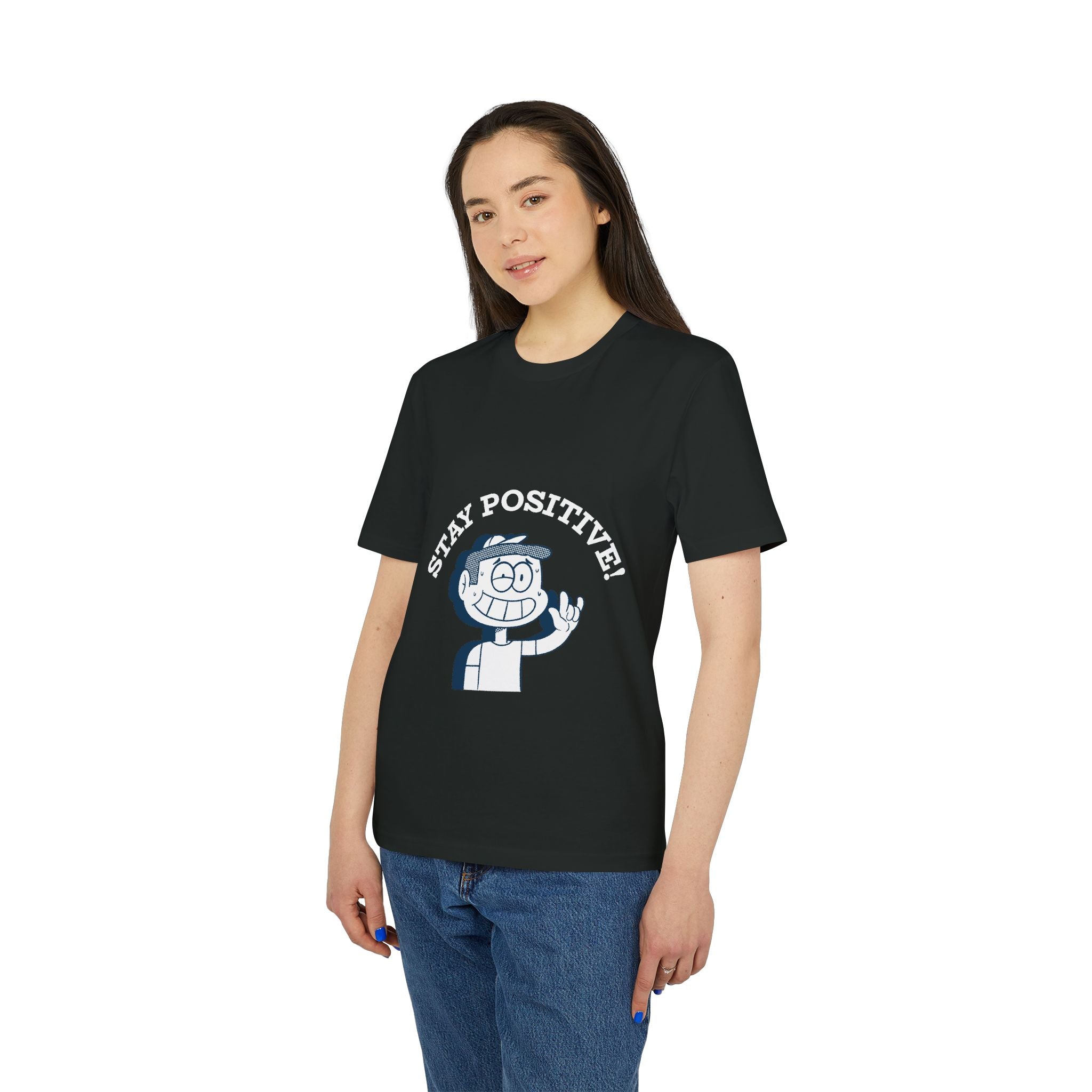 A woman faces the camera against a plain background, wearing the "Stay Positive - Organic T-Shirt," which features a cartoon character and the encouraging message "STAY POSITIVE!.