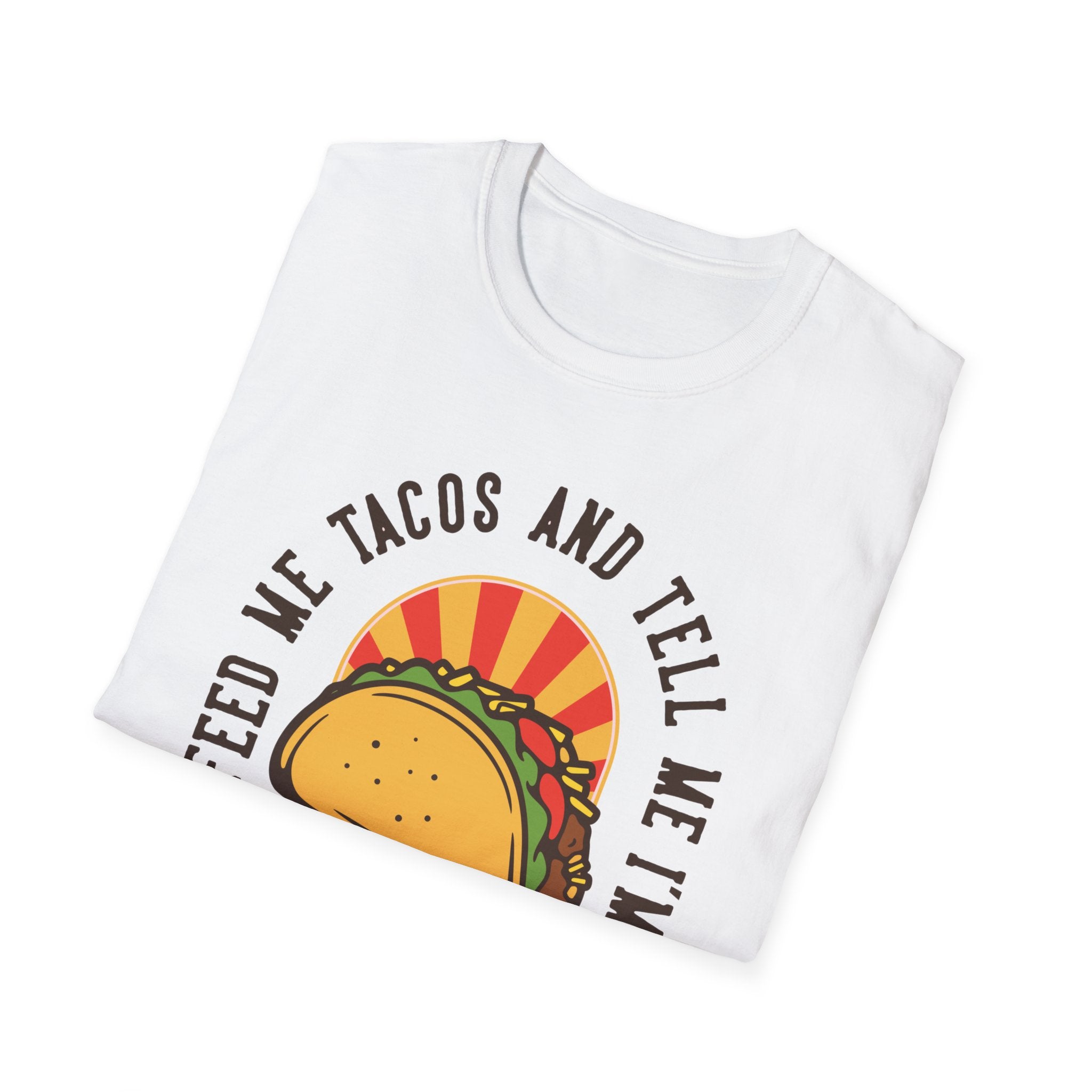 A folded white T-shirt from the "Feed Me Tacos and Tell Me I'm Pretty" collection, showcasing a whimsical design of a taco with the text: "Feed me tacos and tell me I'm pretty" — an ideal choice for taco enthusiasts who love celebrating taco Tuesdays.