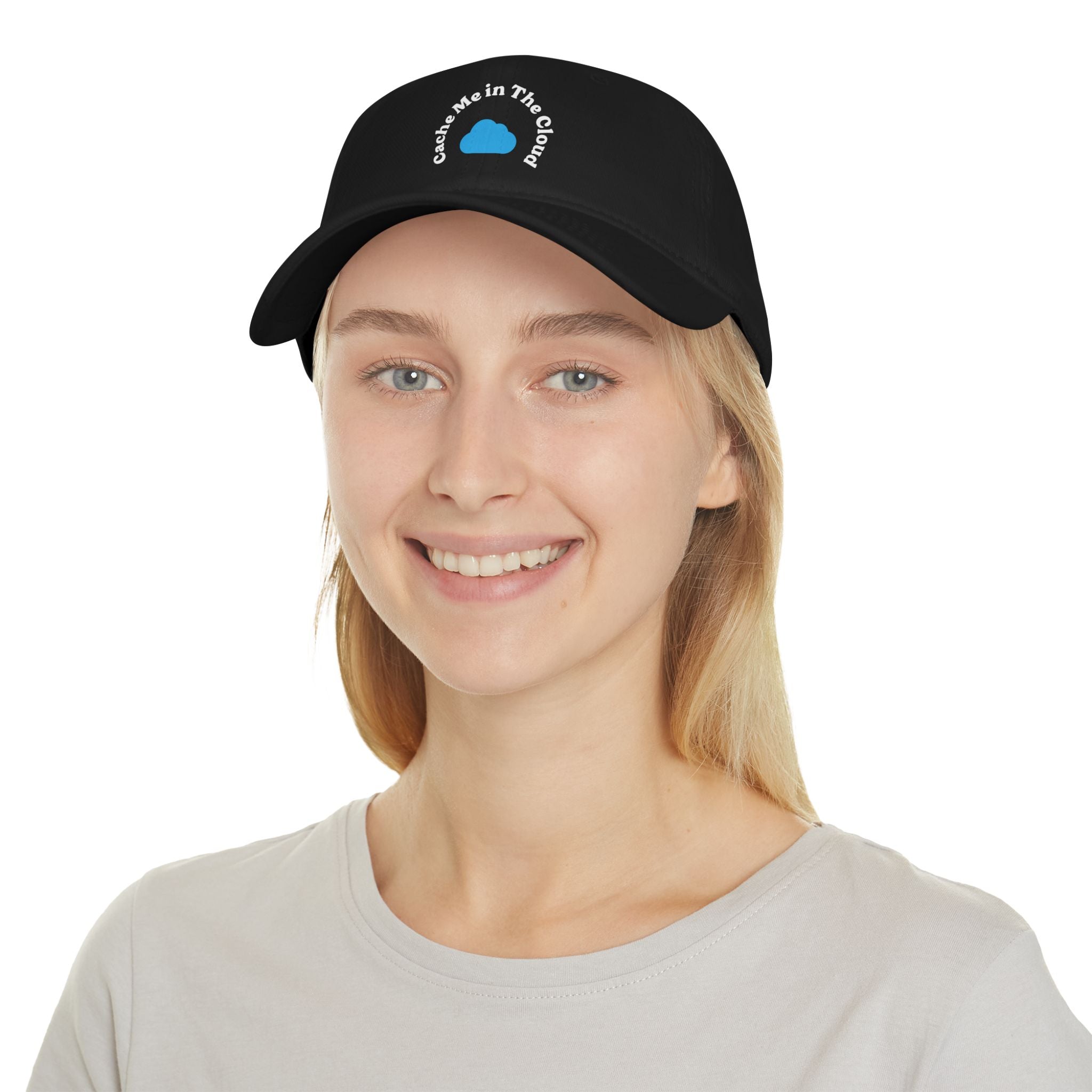 A person sporting the "Cache Me in The Cloud" hat, featuring the blue circle logo, smiles while wearing a light-colored shirt.