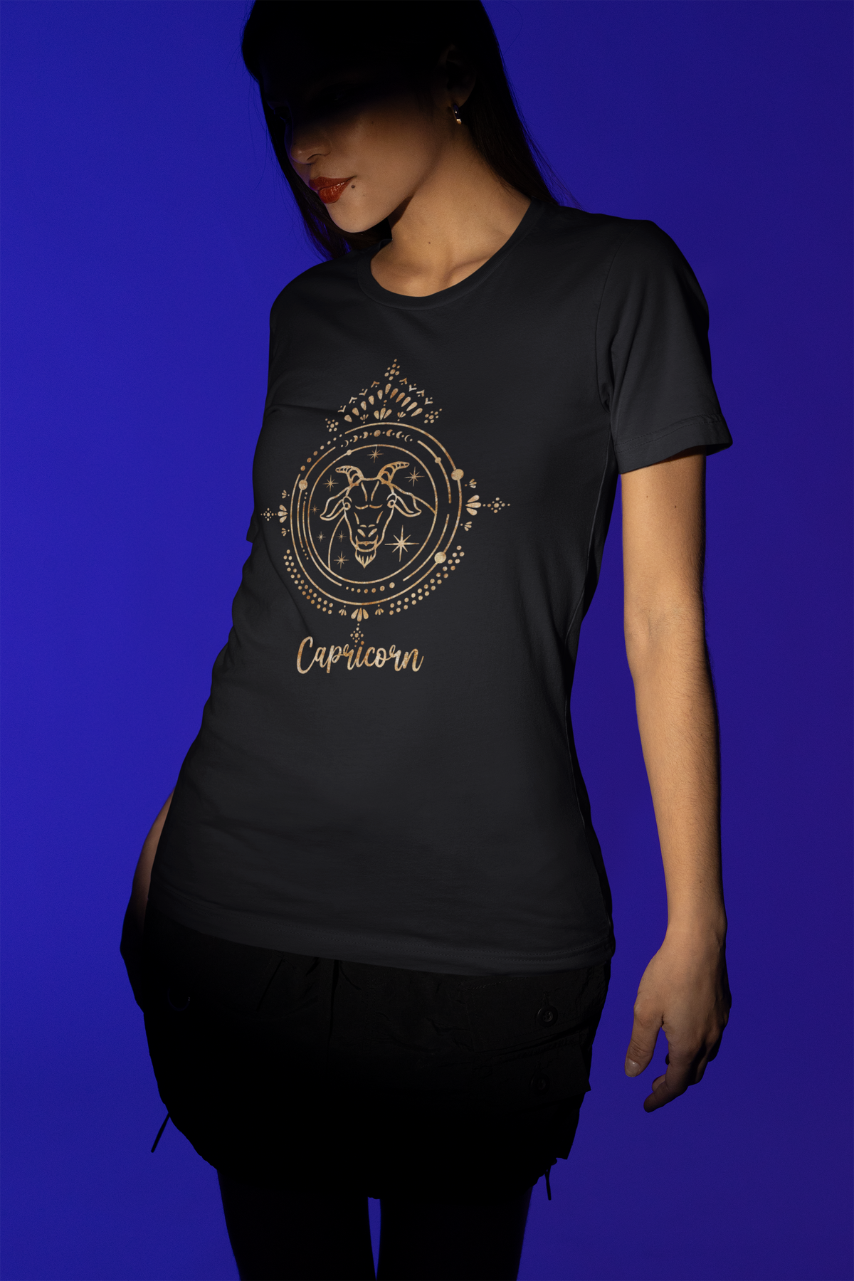Capricorn zodiac T-shirt in black, woman wearing it against a blue backdrop, zodiac gift shirt