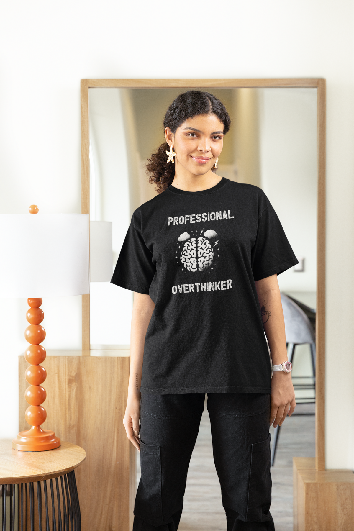 'Professional Overthinker' women's tee in black, woman wearing it at home, funny brain graphic tee