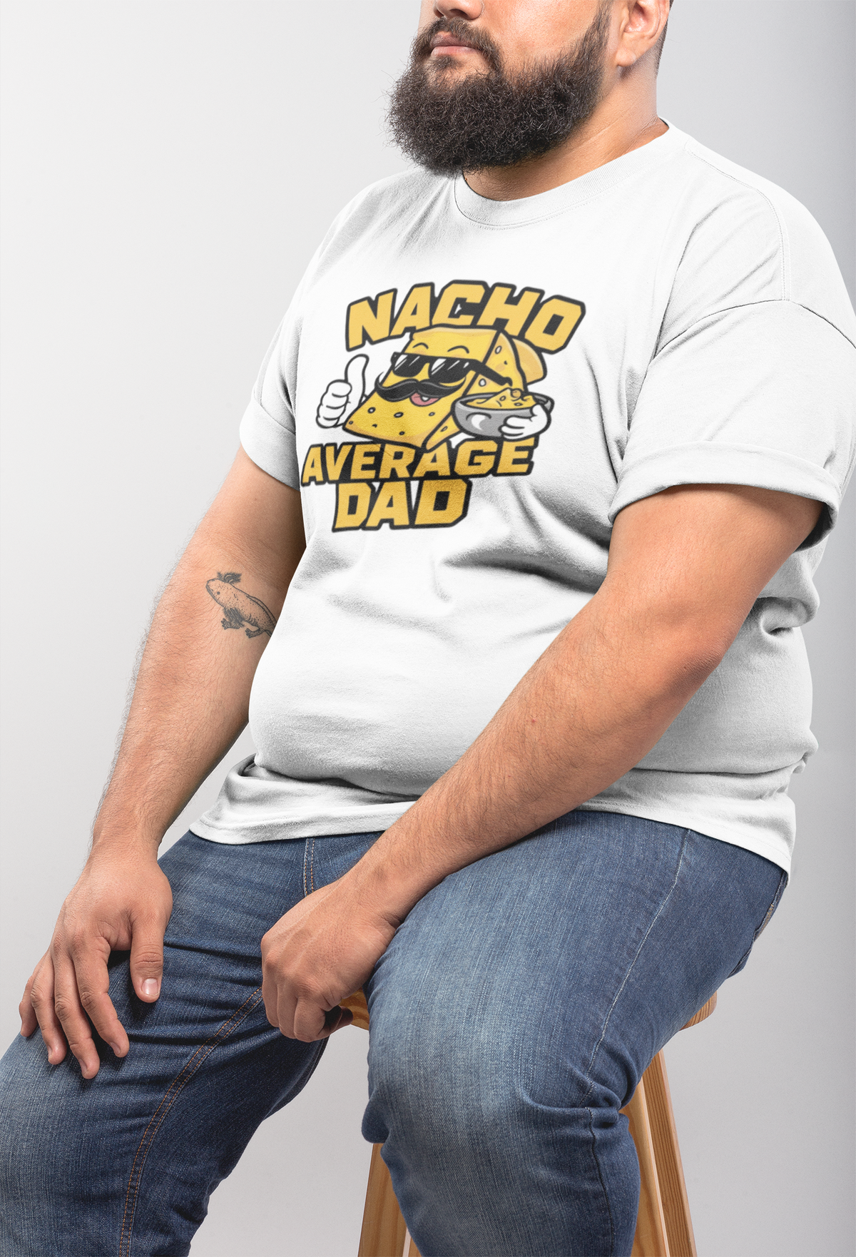 "Nacho Average Dad" t-shirt in white, man modeling it seated, funny Father's Day gift shirt