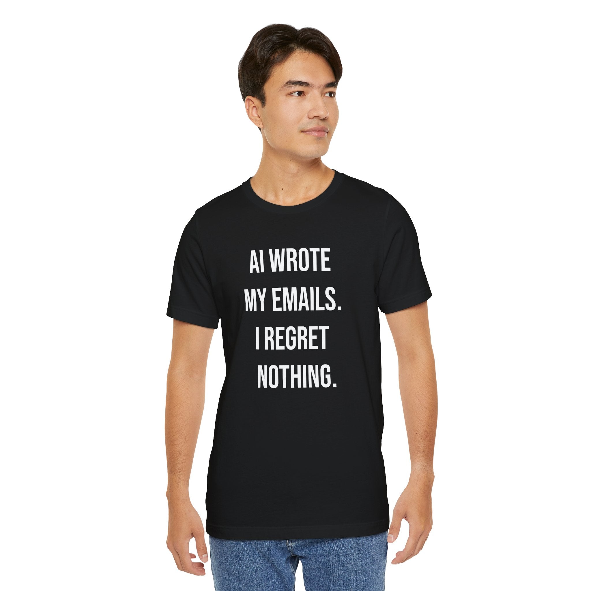 Wearing the "AI WROTE MY EMAILS I REGRET NOTHING -T Shirt," a black tee with white text, someone stands against a plain background—an ideal humor shirt for tech enthusiasts.