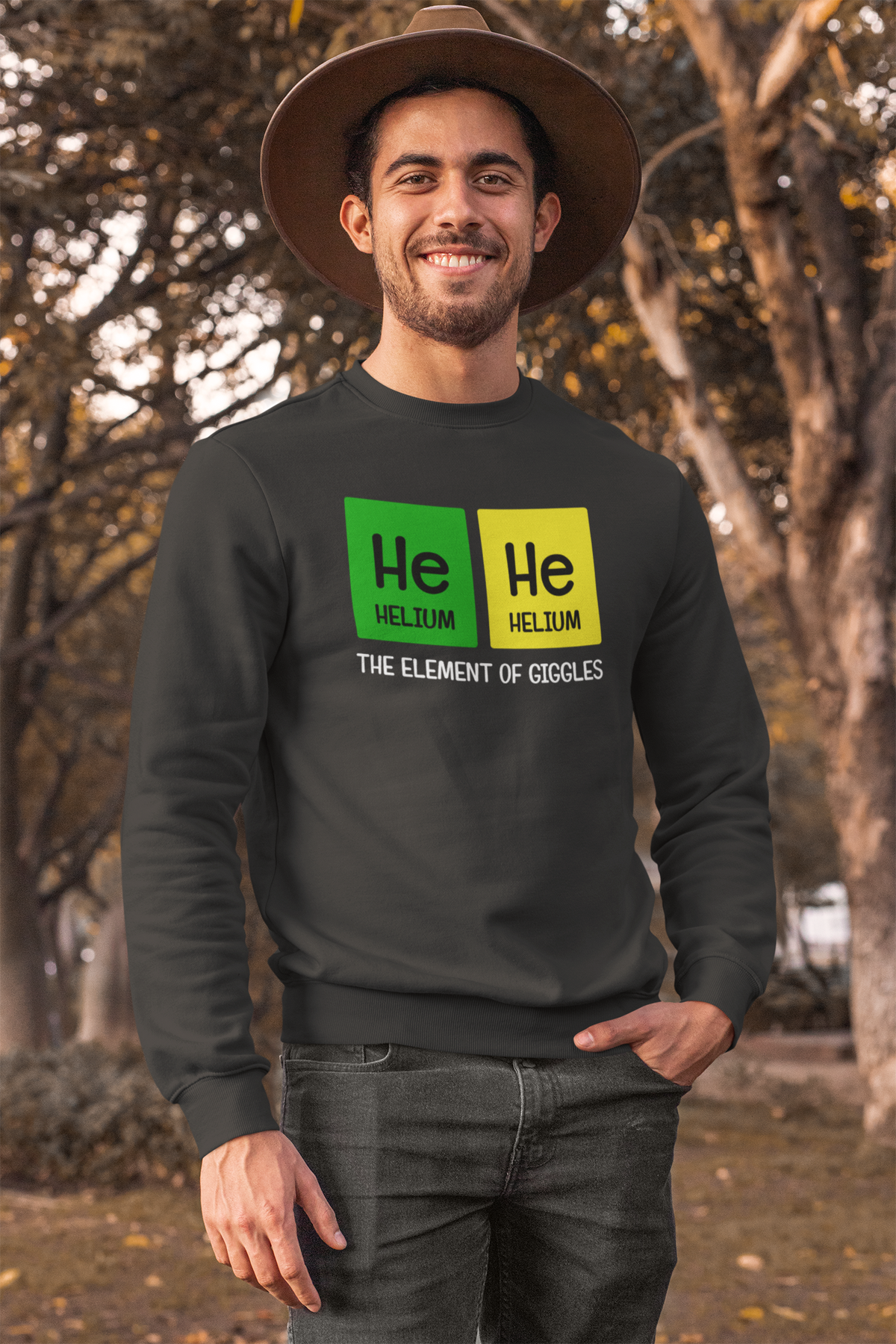 'He-He: The Element of Giggles' sweatshirt in charcoal, man outdoors, funny science gift for him