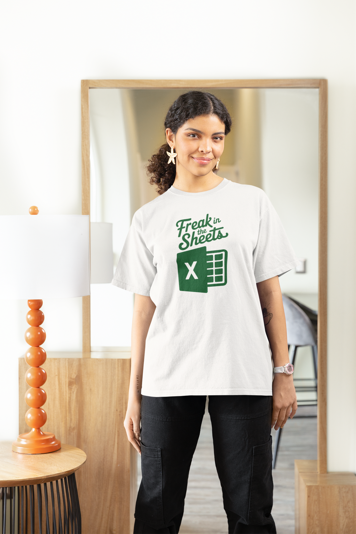 'Freak In The Sheets' womens tee in white, woman standing in living room, funny spreadsheet pun gift