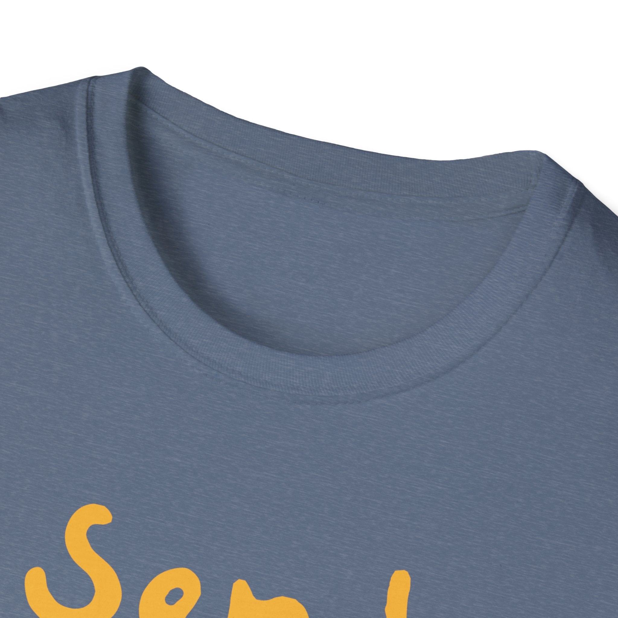 A close-up of a gray "Send Noods" T-shirt collar features a stylish and fashionable fit, with a partial glimpse of yellow script cleverly hinting at a humorous phrase.