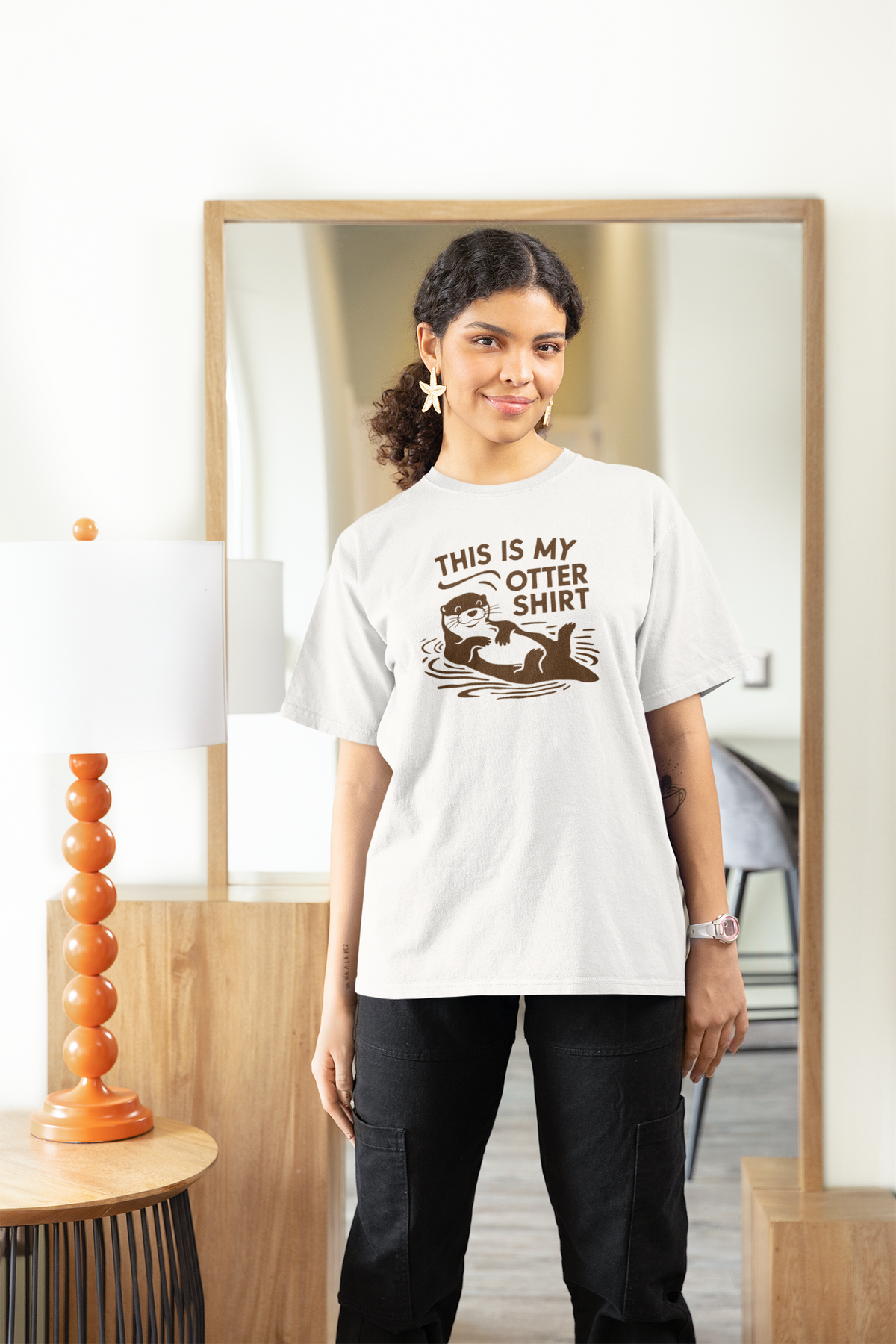 'This Is My Otter Shirt' t-shirt in white, woman wearing it indoors near a mirror, funny animal pun gift
