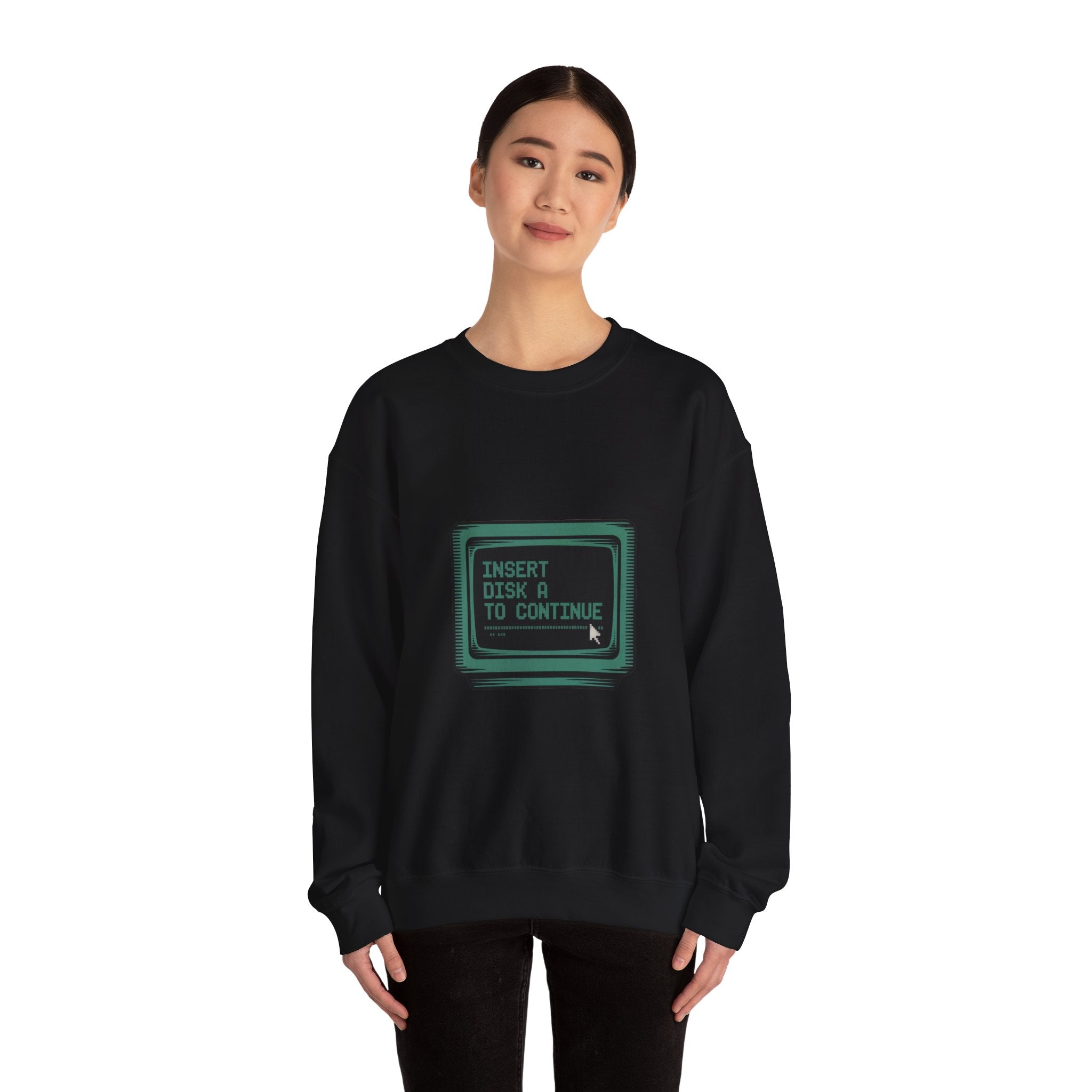 A woman wears the "Insert Disk A to Continue" crewneck black sweatshirt, featuring a vintage computer screen graphic—a unique nod to classic tech style for any sci-fi coder or retro gamer.