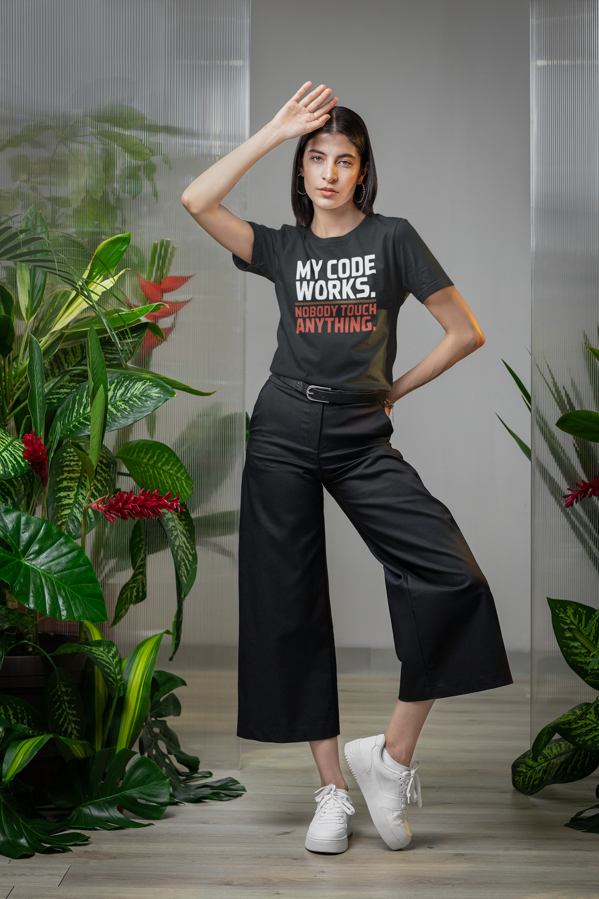 'My Code Works. Nobody Touch Anything.' black tee worn by woman among plants, funny coder gift