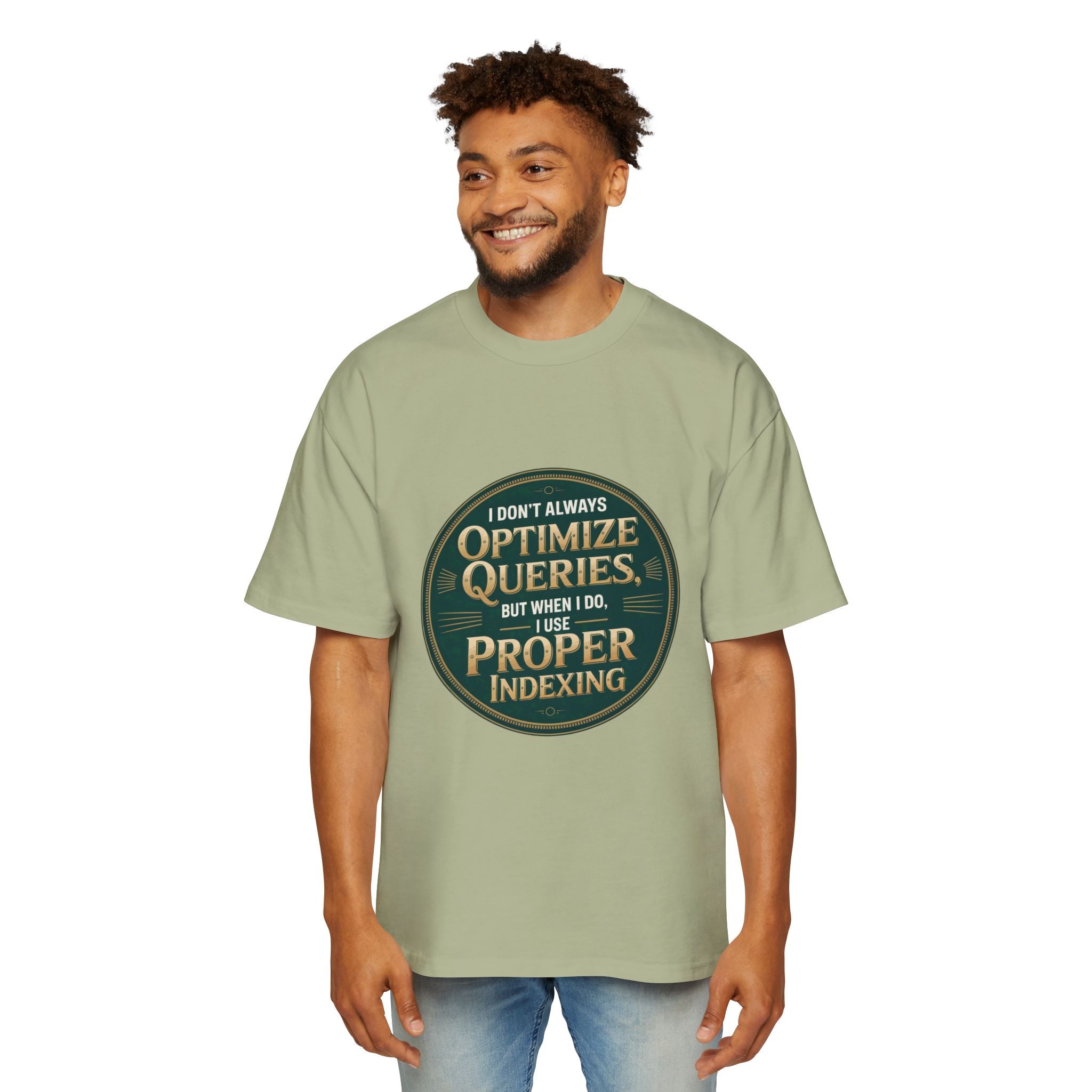 A man smiles in a white backdrop wearing the "I Don't Always Optimize Queries - Heavy Oversized Tee," an oversized light green shirt made of soft carded cotton, featuring the phrase: "I don’t always optimize queries, but when I do, I use proper indexing.