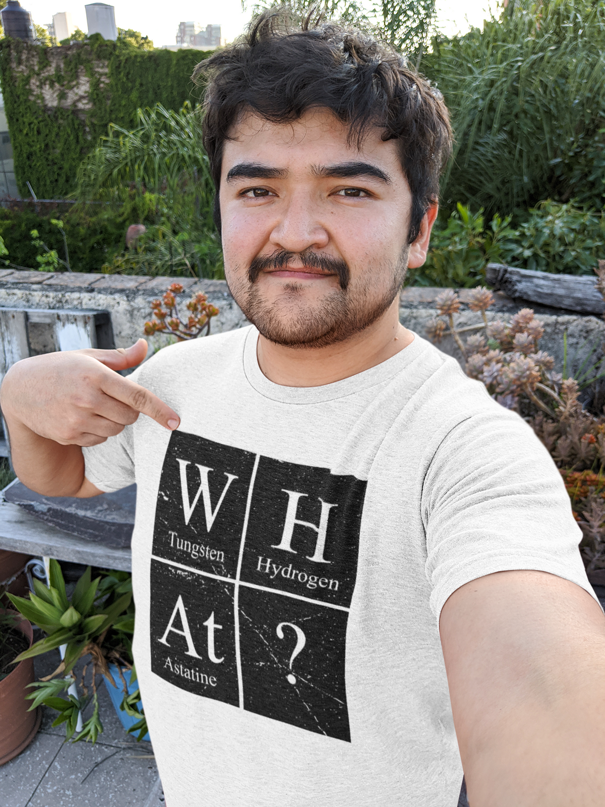 'W-H-At?' periodic table t-shirt in heather grey, man pointing at print outdoors, science gift