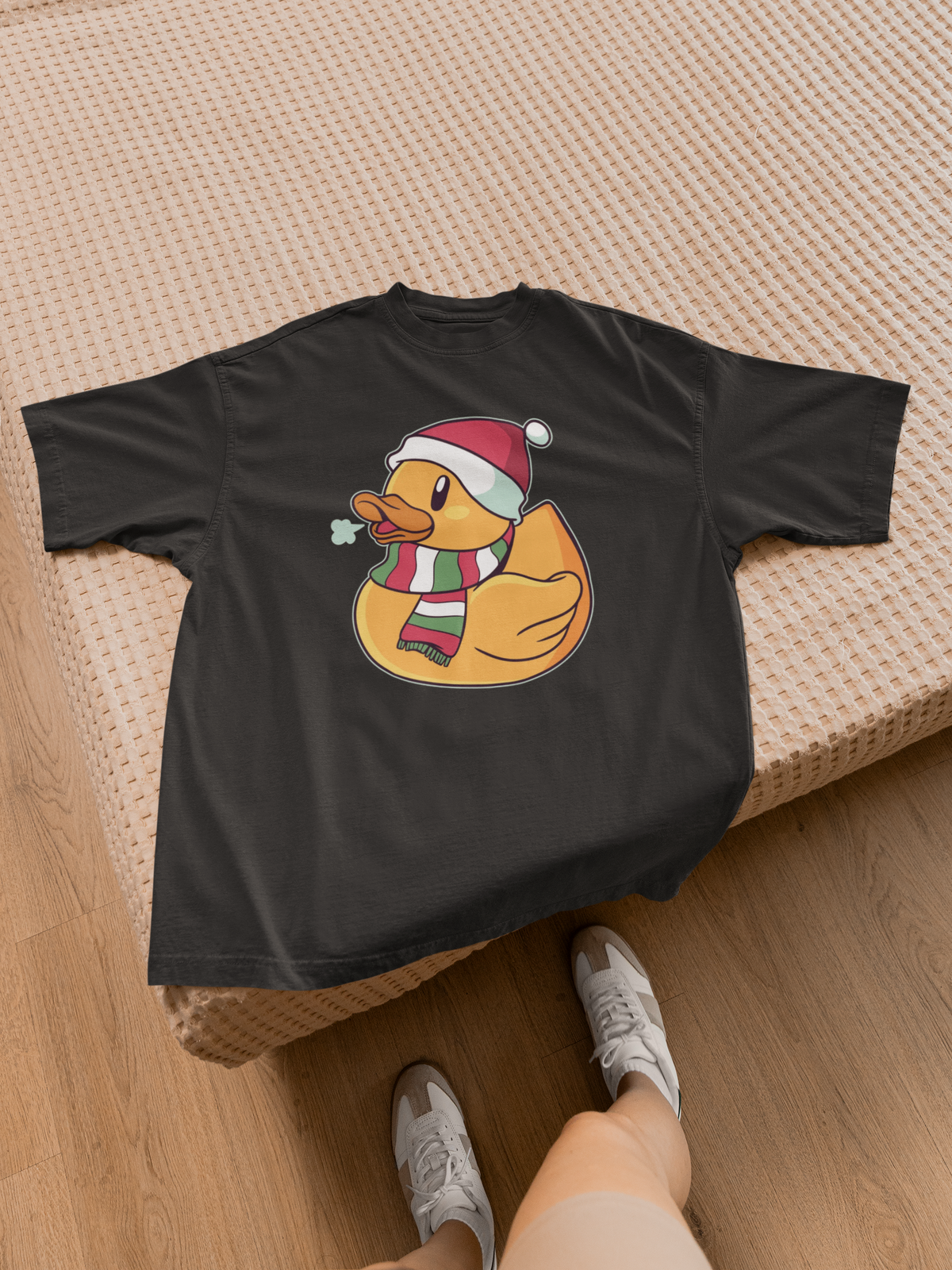 Windy winter duck t-shirt in black, flat lay on a wooden bed frame, funny holiday gift for duck lovers