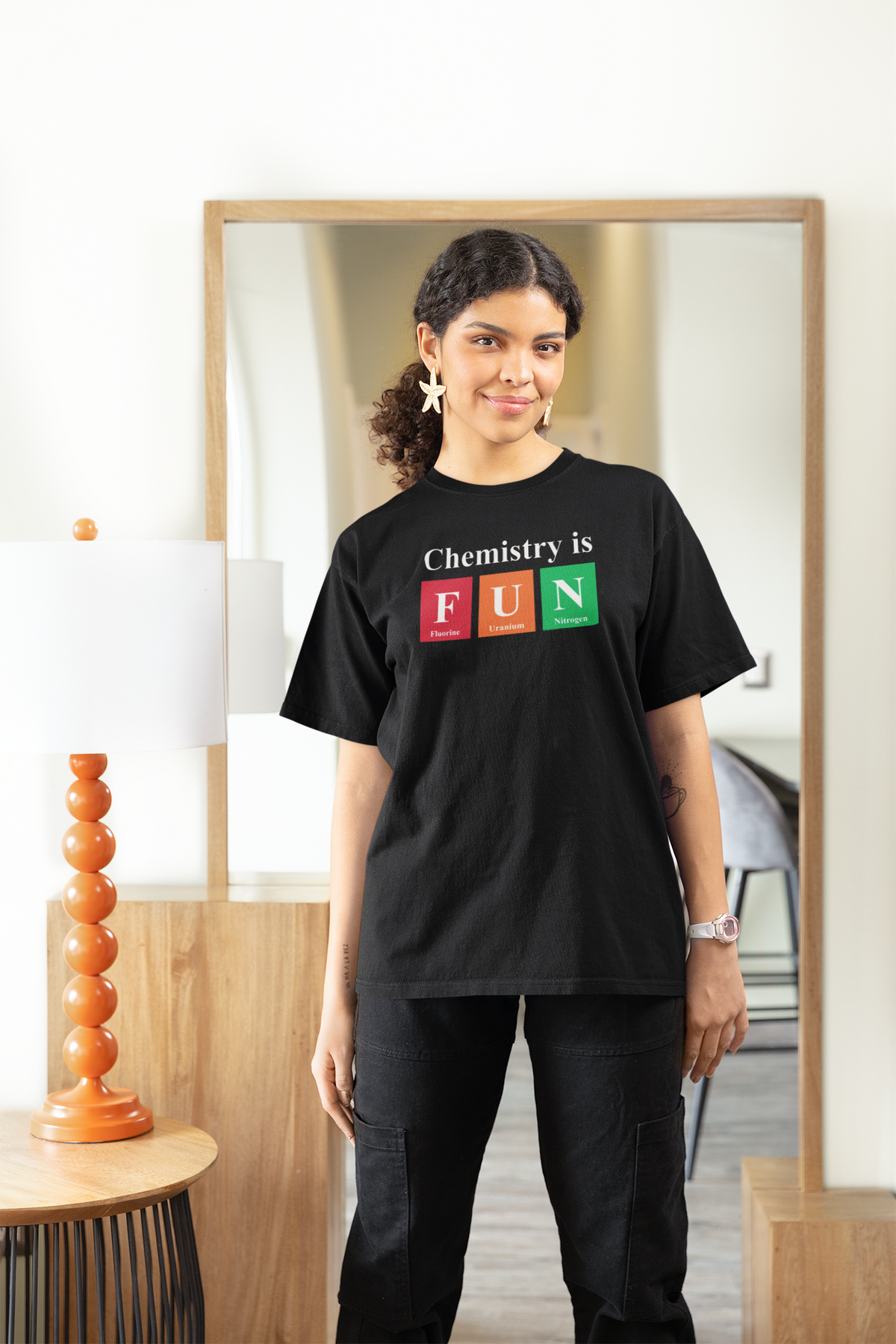 'Chemistry is FUN' women's fitted t-shirt in black, woman wearing it oversized at home, cozy science teacher gift