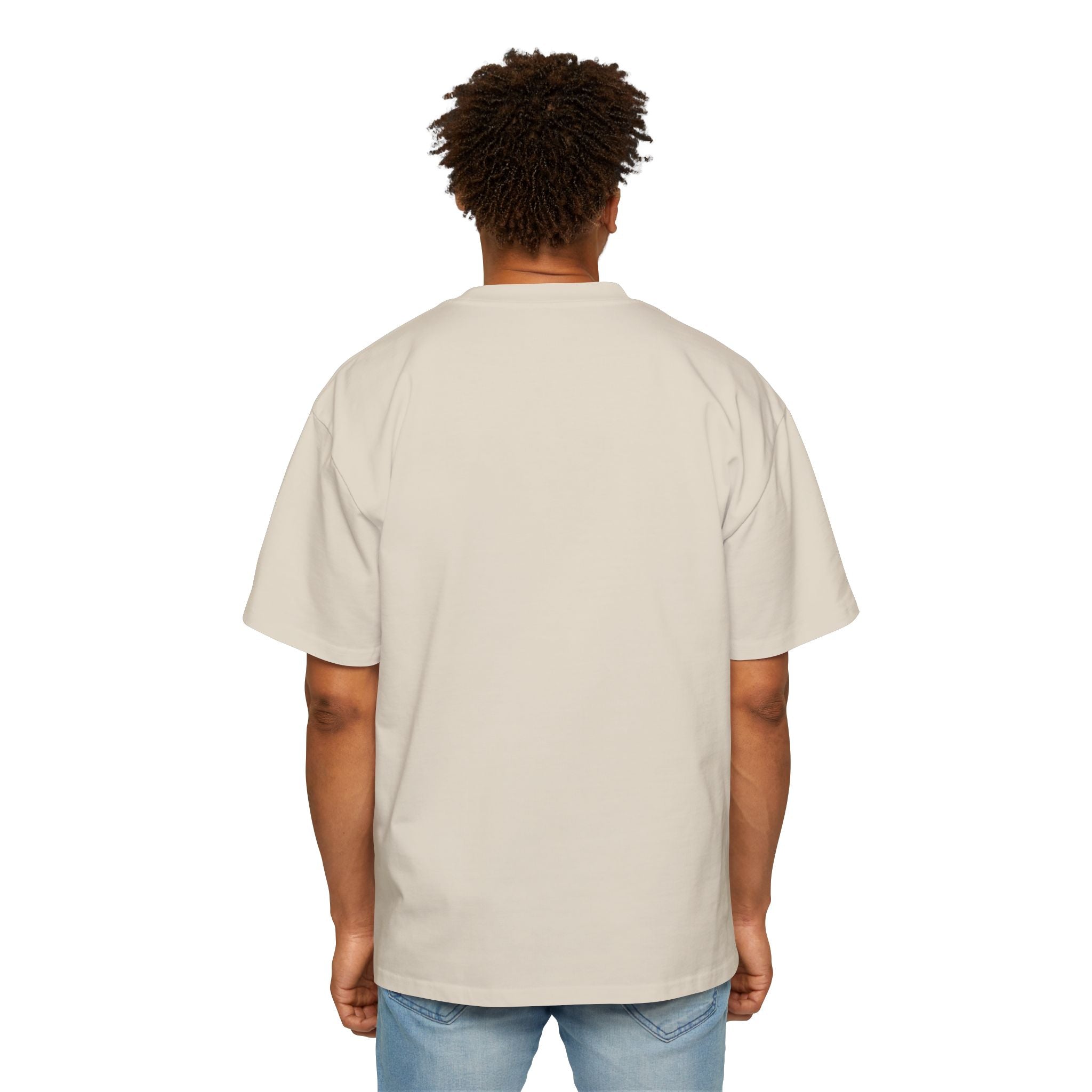 A person stands with their back to the camera, wearing blue jeans and a light beige "Blockchain developer - Heavy Oversized Tee" made from 100% cotton.