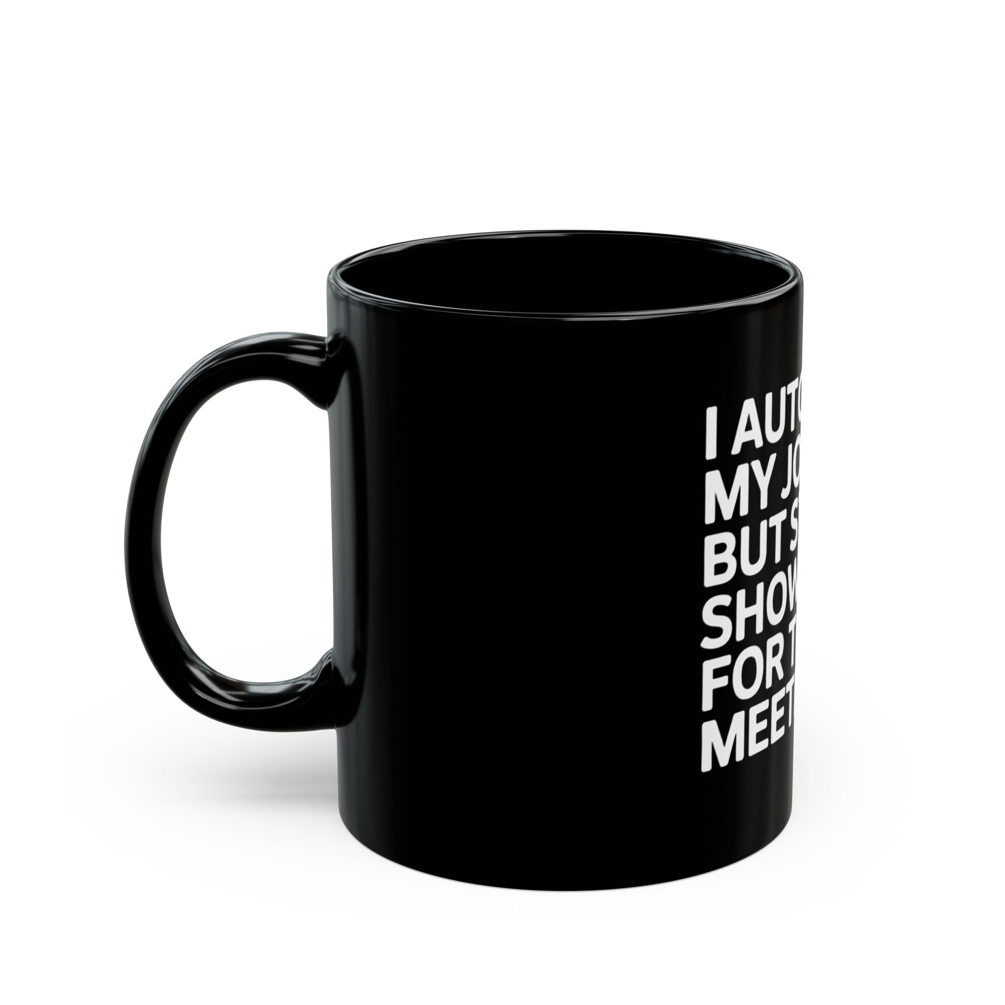 A black ceramic mug with the text "I automated my job but still show up for the meetings" in white on the front, perfect for any programmer's collection. The handle is on the left.