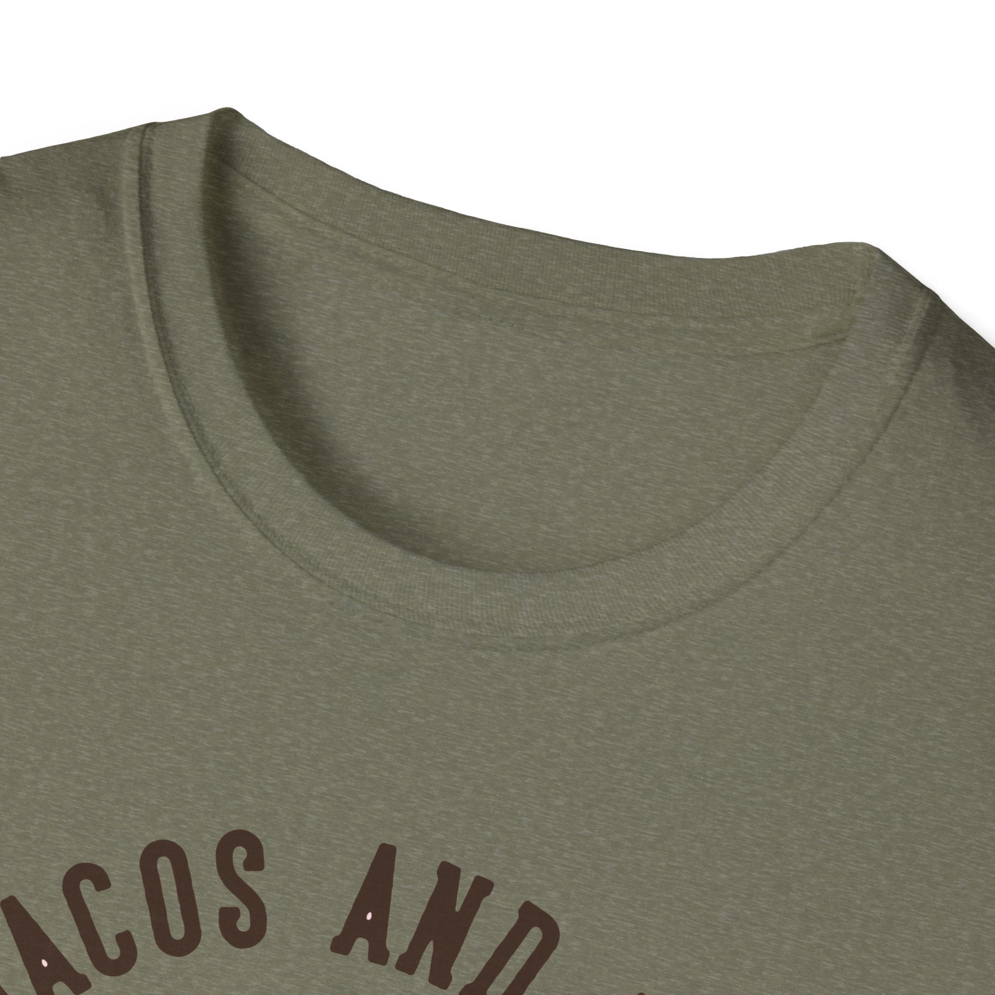 Close-up of a green "Feed Me Tacos and Tell Me I'm Pretty" T-Shirt with partial text displaying the words "TACOS AND" in a dark font, perfect for taco lovers to celebrate taco Tuesdays in style.