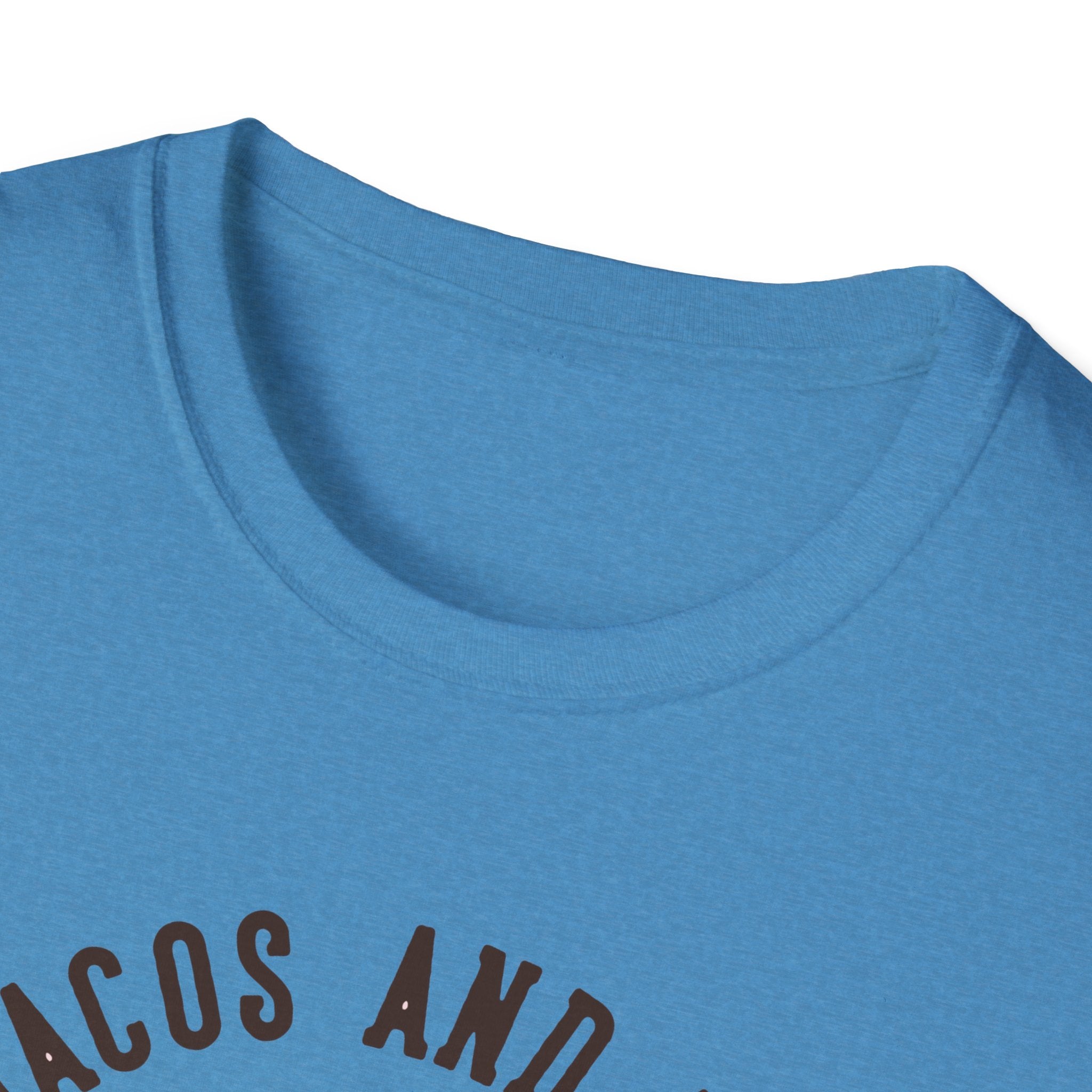 Close-up of a blue "Feed Me Tacos and Tell Me I'm Pretty" T-Shirt with partial black text visible on the front, perfect for taco lovers gearing up for Taco Tuesdays.