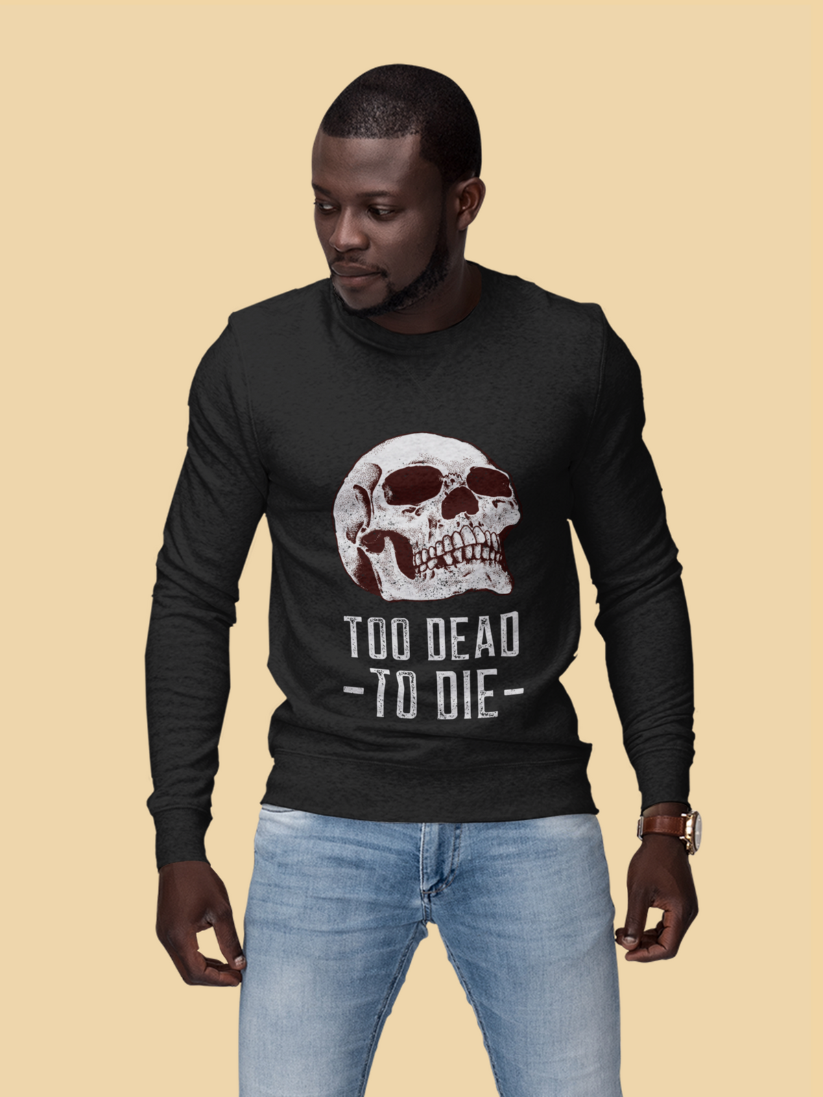 'Too Dead To Die' skull graphic sweatshirt in black, man wearing it against a tan backdrop, gothic gift