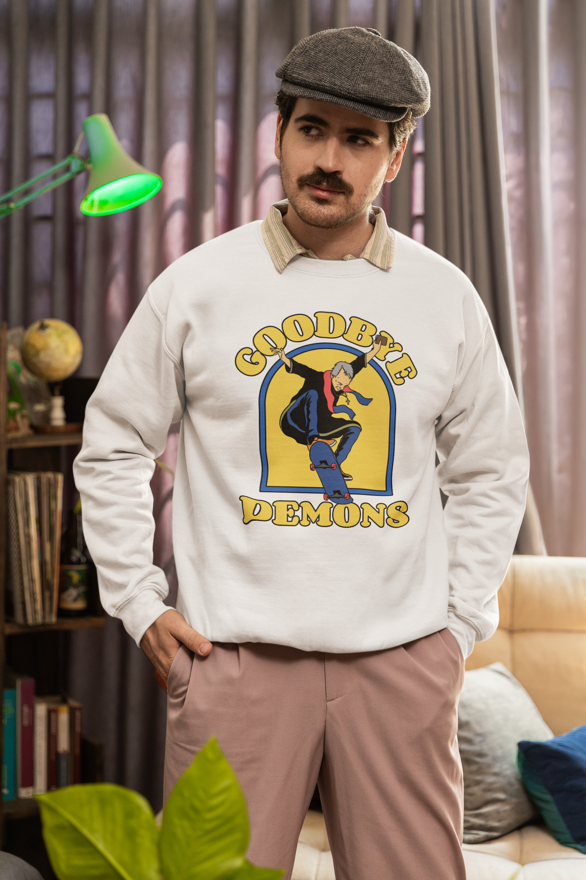 'Goodbye Demons' funny exorcist skater sweatshirt in cream, man wearing it indoors, funny halloween gift