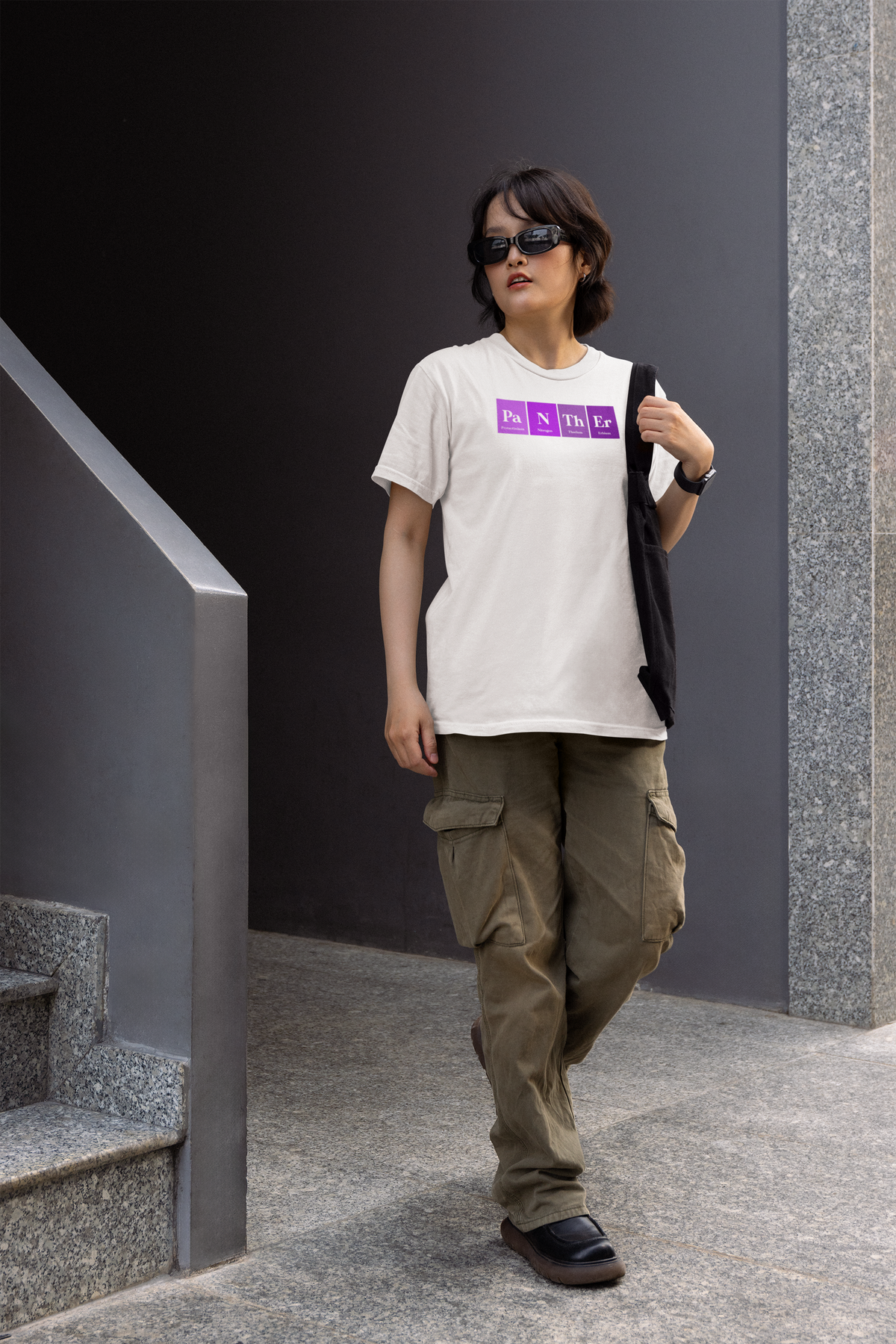 'Pa-N-Th-Er' periodic table women's tee in white, woman walking outdoors, casual streetwear photo
