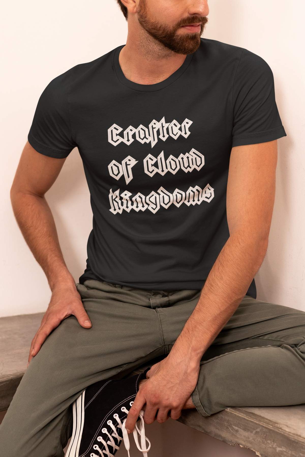 'Crafter of Cloud Kingdoms' organic t-shirt in black, man sitting wearing it, funny gift for coders